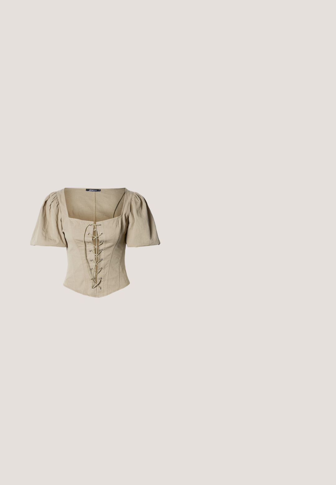 Corset beige avec un décolleté carré, des manches courtes bouffantes et un devant à lacets avec œillets argentés et lacets verts. Tissu texturé.; Culottes larges marron foncé avec plis devant, poches latérales, taille avec fermeture par bouton et un ourlet tombant à mi-mollet.; Sandales plates brunes avec plusieurs brides, ornées de clous dorés et d'une sangle à boucle au niveau de la cheville. Semelle lisse avec un design minimaliste.; Lunettes en écaille de tortue avec des verres ovales, dotées d'une finition brillante, de branches fines et de motifs subtils ressemblant aux rayures d'un tigre.; Sac fourre-tout rayé rouge et beige avec des poignées en cuir rouge et une fermeture à boucle dorée, debout sur un fond uni.; Collier en chaîne dorée présentant un pendentif orné avec des détails complexes, de petits charmeurs et des accents clairs, sur un fond uni.