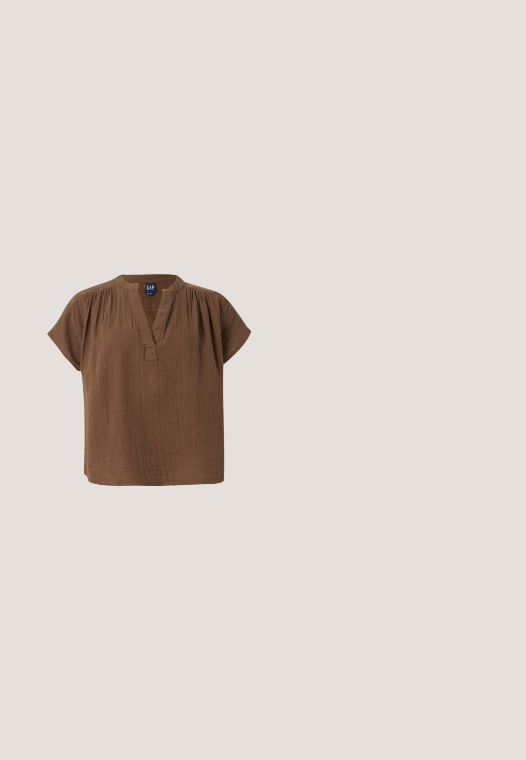 Blouse en coton marron à manches courtes, col en V et détails froncés aux épaules, étiquetée GAP, présentée sur un fond clair uni.; Shorts vert olive avec ceinture à nouer, design plissé et poches latérales. Fabriqués en tissu texturé, avec des bords nets et une coupe décontractée.; Marco Tozzi Escarpins - cinnamon; Lunettes de soleil fines à monture métallique dorée avec verres ovales teintés gris et plaquettes de nez réglables sur fond blanc.; Sac à bandoulière en daim marron avec une large sangle et de longues franges des deux côtés, présenté sur un fond clair uni.; Bracelet manchette ouvert en or avec des segments arrondis aux bords lisses et une finition polie légèrement texturée.