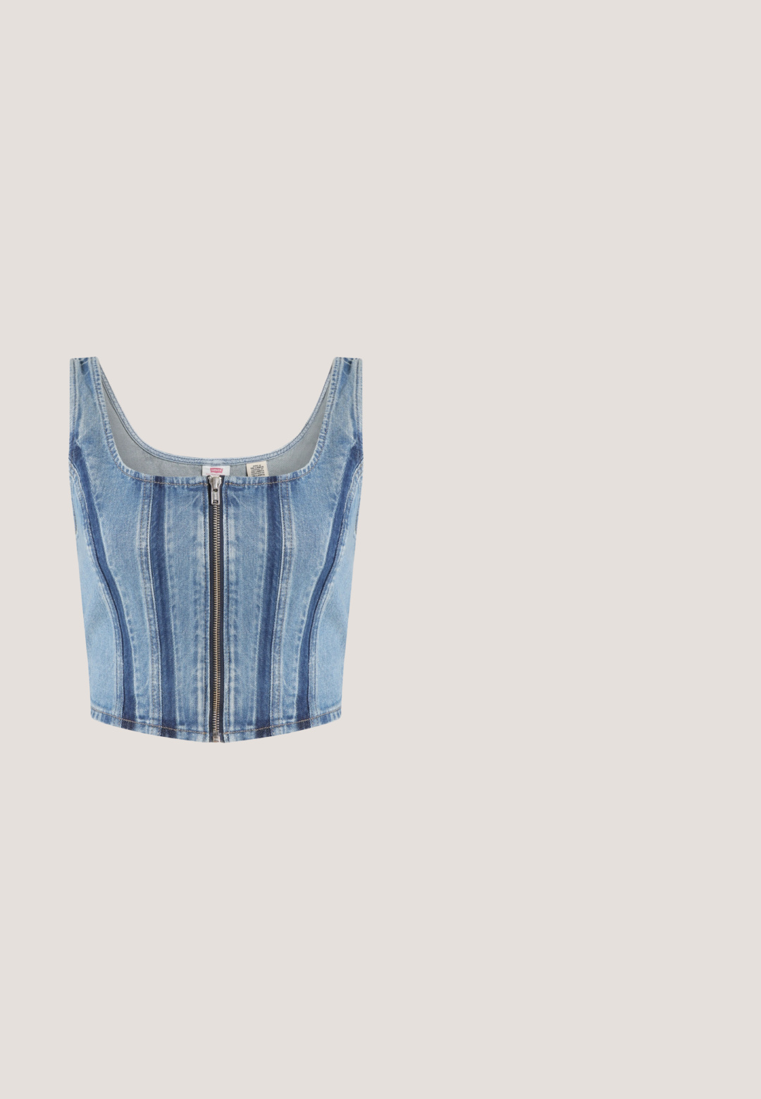 Mouwloze cropped denim top met ritssluiting aan de voorkant en verticale accenten in donkerder blauw.; Roze fluwelen rok met gerimpelde zoom, koord taille en zilveren accenten. Gladde textuur met een casual ontwerp.; Zilveren open teenschoen met brede band, vierkante neus en lage kittenheel op witte achtergrond.; Rode kunststof zonnebril met vierkante montuur, donkergrijze lenzen en zijaccenten. Lichtgewicht ontwerp geschikt voor casual gebruik.; Blauwe met kristallen bezette handtas met zwarte band, voorzien van een verticale zilveren strass-streep in het midden en een strikvormige versiering op de voorflap.; Zilverkleurige broche in de vorm van een vleugel, versierd met ronde en baguette geslepen heldere kristallen die in een gelaagd ontwerp zijn gerangschikt.