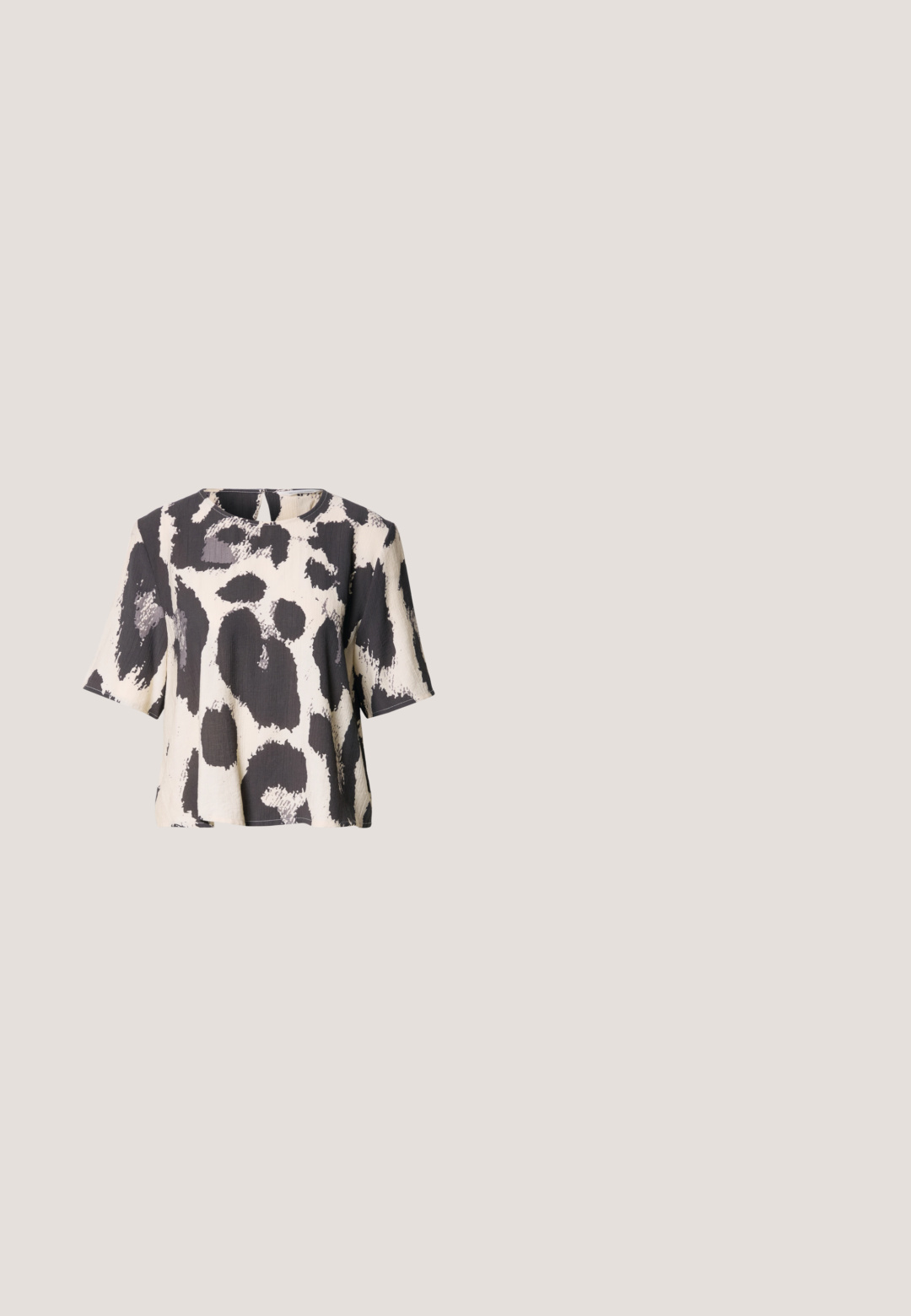 Top de manga corta en blanco y negro con un patrón abstracto texturizado que presenta formas audaces de pinceladas y un escote redondo.; Falda negra con cintura ancha y detalle de lazo. Fabricada en tejido suave, presenta una silueta acampanada y un dobladillo a la altura de la rodilla.; Sandalia negra de tacón alto con puntera puntiaguda de malla, finas correas en el tobillo y tacón de aguja curvado sobre fondo blanco.; Gafas de sol ovaladas negras con montura gruesa y lentes con tintado oscuro, apoyadas sobre una superficie clara.; Bolso de mano de cuero negro liso con correa delgada para la muñeca, forma rectangular y logo sutil en relieve centrado en el frente.; Par de objetos ovalados de plata, lisos y brillantes, colocados uno al lado del otro sobre un fondo blanco puro.