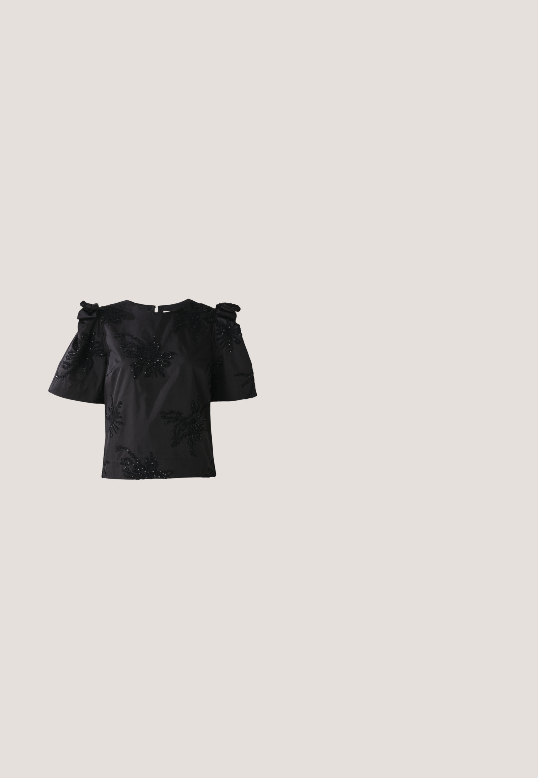 Haut noir à manches courtes avec un col rond, présentant des motifs de feuilles brodés et des sequins. Les manches sont dotées de détails froncés pour plus de volume.; Jupe crayon noir en sequins avec un ourlet texturé et duveteux. Présente une forme ajustée et une surface brillante, créant un contraste saisissant de matériaux.; Pump à talon haut en cuir verni noir avec un bout pointu et une silhouette épurée, présentant une texture lisse et un design minimaliste.; Lunettes de soleil noires avec une forme surdimensionnée en œil de chat, verres gris dégradés et accents en cristal décoratifs sur les branches. Monture en plastique lisse.; Sac à main noir recouvert de clous en argent rectangulaires, doté de deux poignées noires et d'une forme rectangulaire structurée. Base solide.; Collier en argent avec des motifs floraux, orné de pierres précieuses transparentes, avec des détails complexes et un fermoir ajustable.