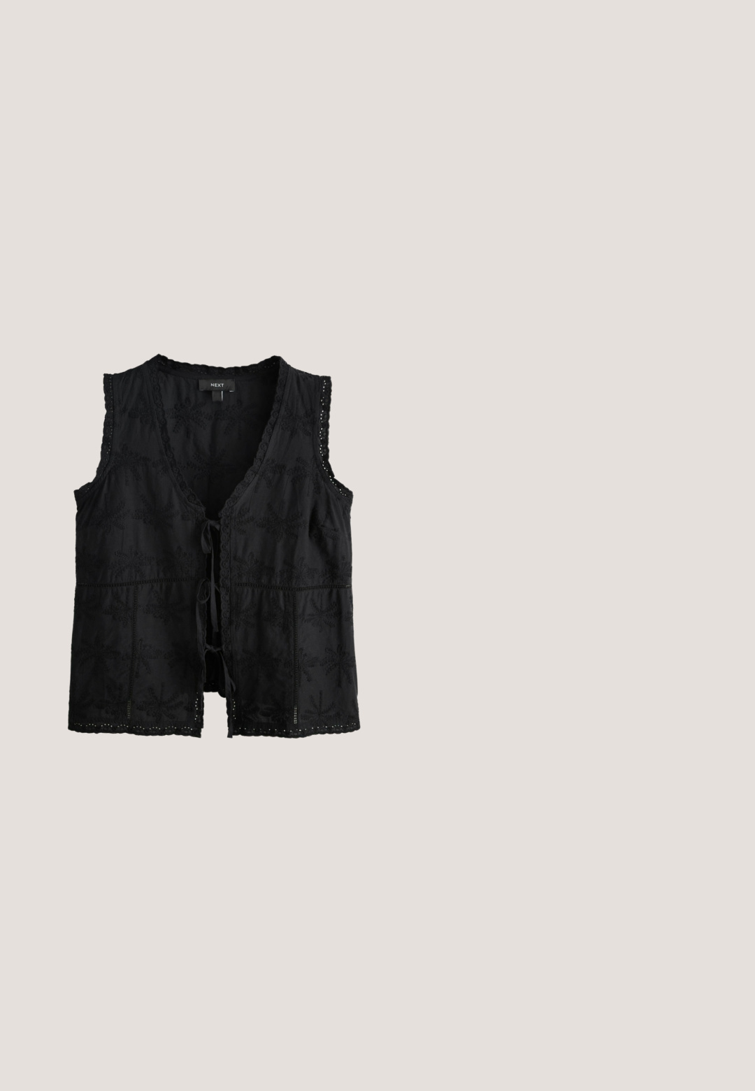 Schwarze ärmellose Weste mit Blumenstickerei, Spitzenbesatz und Bindeschluss. Weicher Stoff mit strukturierter Oberfläche und offenem Vorderteil.; Dunkelbraune Shorts mit elastischem Bund und wellenförmigem Saum mit Lochstickerei-Muster.; Schwarze Gummiflips mit strukturierter Sohle und Y-förmigem Riemen, seitliche Ansicht vor schlichtem hellem Hintergrund.; Schwarze Cateye-Sonnenbrille mit dunklen Gläsern und einem kleinen silbernen Zieremblem an der rechten Bügel.; Schwarze geflochtene Bucket-Tasche mit bunten gestickten Mustern, zwei kurzen Griffen und einem langen verstellbaren schwarzen Schulterriemen.; Goldkette-Armband mit abwechselnd flachen und strukturierten Gliedern, ausgestattet mit einem Karabinerverschluss und einer verstellbaren Kette mit einem Anhänger.