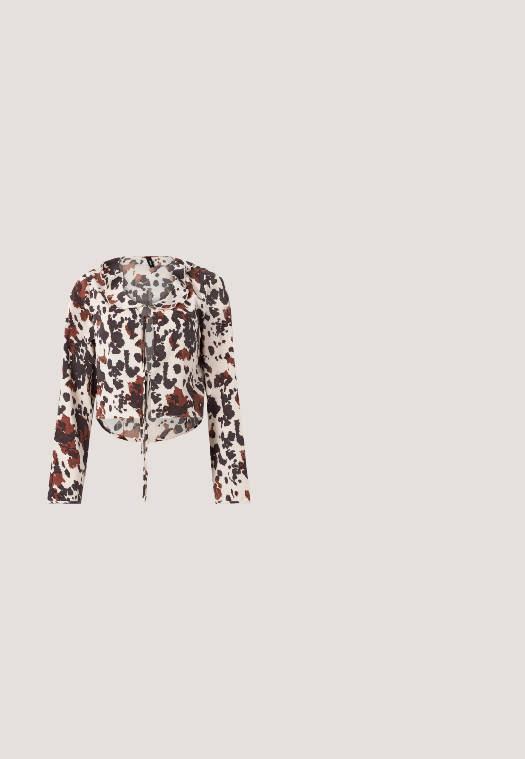 Blouse raccourcie avec cordon de serrage, présentant une base beige et un imprimé abstrait brun et rouge. Manches longues et tissu doux et texturé.; Shorts en tissu brun texturé avec ceinture élastique et ourlets volantés sur un fond uni clair.; Mule en satin marron à bout ouvert avec un talon fin de hauteur moyenne et une conception à enfiler sur fond blanc uni.; Lunettes de soleil rondes teinte brun avec une monture bordeaux brillante. Branches fines avec un détail de marque subtil. Design de verres plats.; Sac à bandoulière rectangulaire en cuir marron foncé avec une seule sangle fine et une boucle dorée sur un fond uni.; Boucles d'oreilles dorées avec une forme abstraite et organique, présentant une surface texturée et une fermeture à poussette.