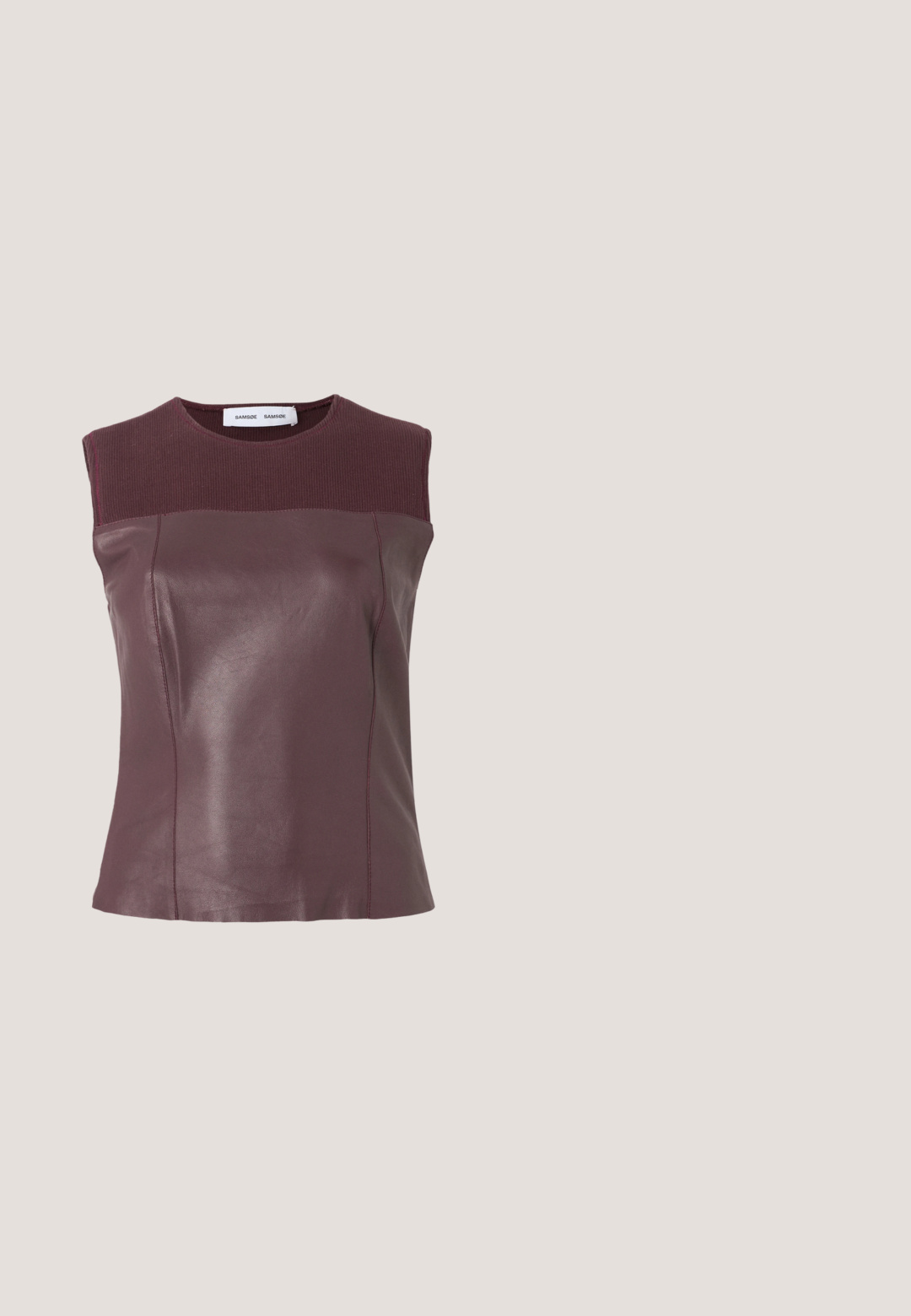 Bordeauxrode mouwloze top met een glad leren lijfje en geribbelde stof bij de halslijn en schouders; aangesloten silhouet met naaddetails.; Zwarte broek van een gladde, rekbare stof, met een aansluitende taille, riemlussen en licht uitlopende benen met zijsplits.; Zwarte high-heeled schoen in balans op de hiel op een reflecterende aanrecht bij metalen ordnerhouders met witte mappen.; Crèmekleurige vierkante sjaal met een zwart abstract lusvormig randontwerp.; Beige leren handtas in halvemaanvorm met een enkele schouderband en minimale stiksels, afgebeeld tegen een effen witte achtergrond.; Gouden oorbellen met een gladde, ronde vorm en gepolijste afwerking. Voorzien van een clip-on stijl voor gemakkelijk dragen.