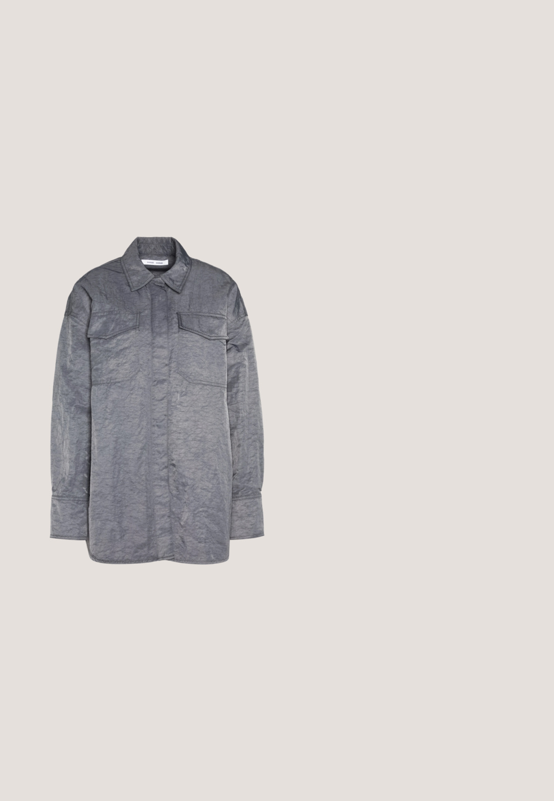 Chemise grise à boutons en tissu froissé. Elle présente un col, des manches longues et deux poches poitrine. Surface texturée.; Pantalons à jambe large en tissu gris doux. Dotés d'une fermeture à bouton et de coutures nettes. Texture lisse sans motifs ni embellissements visibles.; Mocassin en cuir noir avec semelle épaisse rainurée, couture moc toe, détail de sangle sur le dessus et languette au talon, présenté de profil.; Des lunettes rectangulaires noires avec des verres transparents. Fini brillant, branches étroites et teinte violette visible sur les bords des verres.; Sac à main gris texturé avec une poignée rembourrée, des accents en maille, une bandoulière ajustable et un fermoir à l'avant. Design compact avec une forme arrondie.; Boucles d'oreilles en argent en forme de cerceau avec un charme croix et cœur. Texture lisse et brillante avec une finition polie. Chaque charmepend d'une boucle sécurisée.
