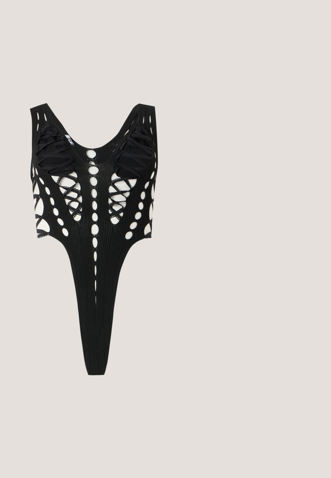 Body negro con patrones recortados y detalles de cordones, presentando una espalda descubierta y una textura acanalada. Aperturas de pierna altas.; Leggings negras con una tela suave y elástica, cintura alta y un diseño ajustado. No presentan patrones ni acentos visibles.; Sandalia de tacón alto de charol negro con puntera abierta y fina correa de tobillo con hebilla sobre fondo blanco.; Gafas de sol de plástico negro con lentes gris degradado. Forma cuadrada con acabado brillante, presentando un acento del logo dorado en la patilla.; Bolso de cuero negro texturizado con asas dobles, cierre dorado con letras entrelazadas y correa de hombro desmontable sobre un fondo liso.; Pendientes florales de oro con pétalos texturizados y un anillo de pequeñas piedras transparentes, un pendiente con dos cadenas colgantes de diminutas piedras.