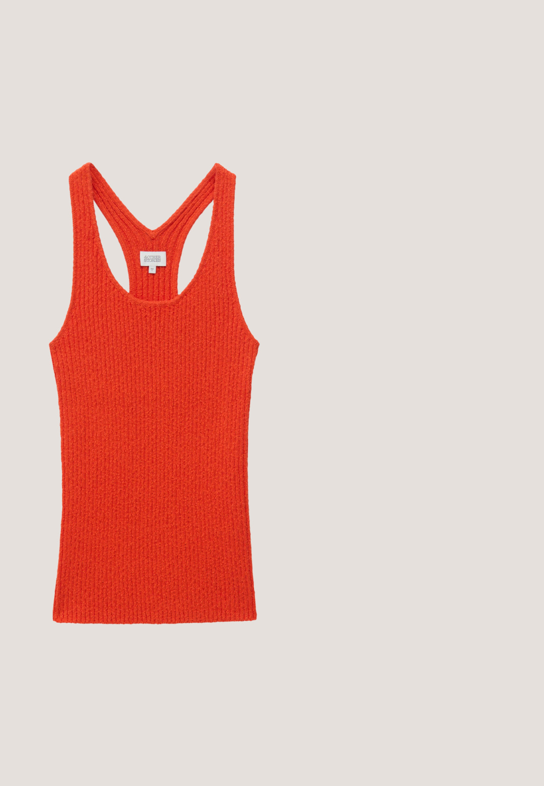 Débardeur en maille côtelée orange vif avec un dos nageur et un col rond, présenté à plat sur fond blanc.; Jupe enveloppante orange avec des pois dorés, ourlet en volants et lien sur le côté. Fabriquée en tissu léger, présentant une texture lisse.; Sandale plate rouge avec un design cage ouverte pour les orteils et une bride de cheville réglable, avec un petit talon noir et une semelle lisse.; Lunettes de soleil écaille de tortue marron avec des verres rectangulaires, des accents dorés sur les côtés et une finition brillante. Présente des détails de logo audacieux.; Pochette ronde en cuir orange en forme de pêche avec une poignée en boucle en cuir vert et un détail de feuille sur le dessus.; Paire de boucles d'oreilles en ton or avec trois segments incurvés de couleur corail sur chaque boucle, posées sur un fond blanc uni.