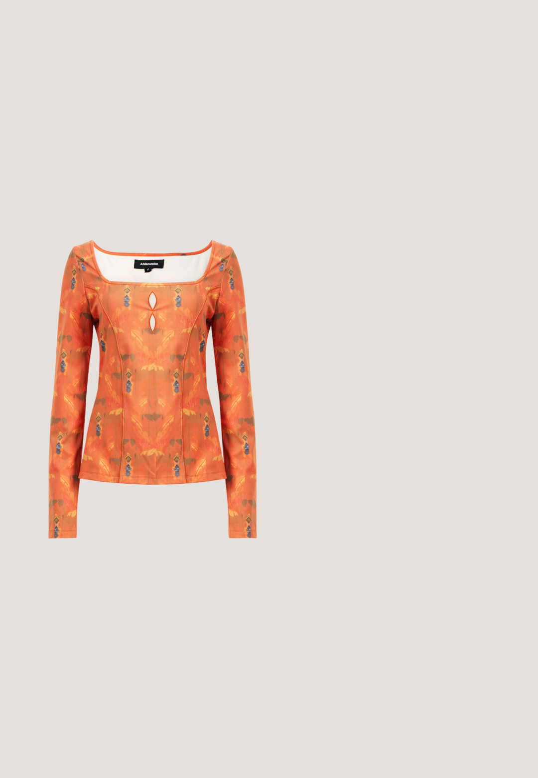 Langærmet top i livlig orange med blomstermønster. Har en firkantet udskæring og dekorativ nøglehulldetalje. Glat stofstruktur.; Rustfarvet omslagsskjørt med illustrationer af sol, blad, bæger og kande, bundet med cremefarvet og blåstribet bånd, tekst "Soleil d'Amour" ved kanten.; Grå læder sandal med hæl, knyttet rem ved tæerne og snørebånd, der vikles om anklen, på slank mellemhøj hæl mod hvid baggrund.; Grønne plastiks solbriller med en oval form, tykke stel og mørkegrønne linser. Har slanke, gennemsigtige arme med subtil branding.; Clutch-taske i cremefarvet læder med en struktureret topramme og håndledsrem, vist mod en enkel lys baggrund.; Chunky guld hoop øreringe med et let snoet, rørformet design og postsystem bagpå, på en hvid baggrund.