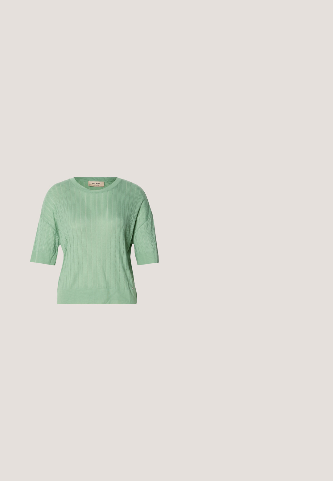 Suéter de manga corta verde menta con textura acanalada, cuello redondo y un ajuste ligeramente holgado. Presenta un pequeño logo en el lateral.; Pantalones de pierna ancha en un estampado de leopardo marrón y negro. Presenta una cinturilla alta y un diseño plisado. Tela suave con una textura lisa.; Botín negro de cuero con puntera puntiaguda y tacón ancho descansando sobre superficie de madera, hierba alta y verde al fondo.; Bolso de mano de cuero negro con una textura suave. Cuenta con una correa ajustable y un diseño elegante y minimalista con cierre de cremallera.; Pendientes de plata con una forma orgánica y abstracta. Superficie lisa y brillante con un diseño cónico. Presentan suaves curvas y un detalle de línea central.; Cinturón de cuero negro con hebilla rectangular plateada, enrollado y descansando sobre una superficie blanca.