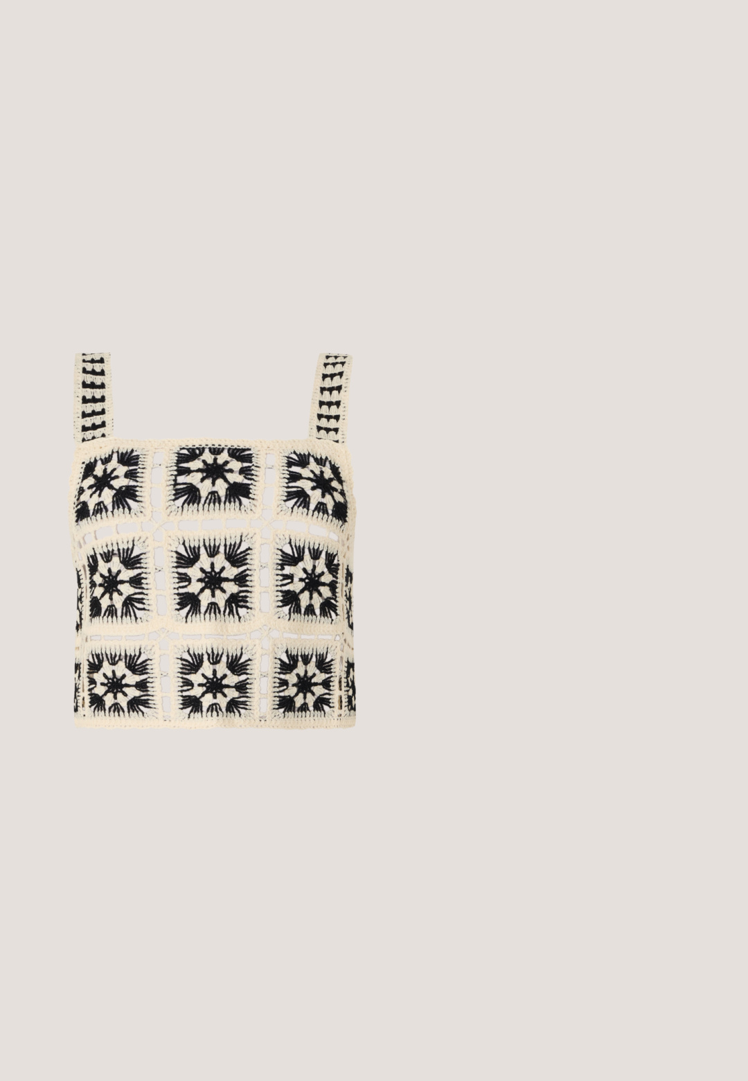 Haut court au crochet avec une base crème et des broderies florales noires, motifs carrés et bretelles ajustables. Le design à mailles ouvertes ajoute de la texture.; Jupe maxi noire et transparente avec une taille élastique, ornée d'un imprimé multicolore de coquillages et de papillons. Tissu léger et fluide.; Chaussures slingback en cuir noir avec un bout pointu, comprenant une lanière étroite et un accent de boucle argentée sur le côté. Semelle plate.; Lunettes de soleil noires avec une monture rectangulaire élégante et des verres bleus. Présente une texture lisse et des branches robustes. Logo de la marque sur le côté.; Sac à main noir froncé avec une poignée froncée, posé sur une sphère en pierre texturée devant un mur en béton beige.; Boucles d’oreilles créoles en métal argenté avec une surface lisse légèrement incurvée et des fermoirs à clapet sur un fond blanc uni.