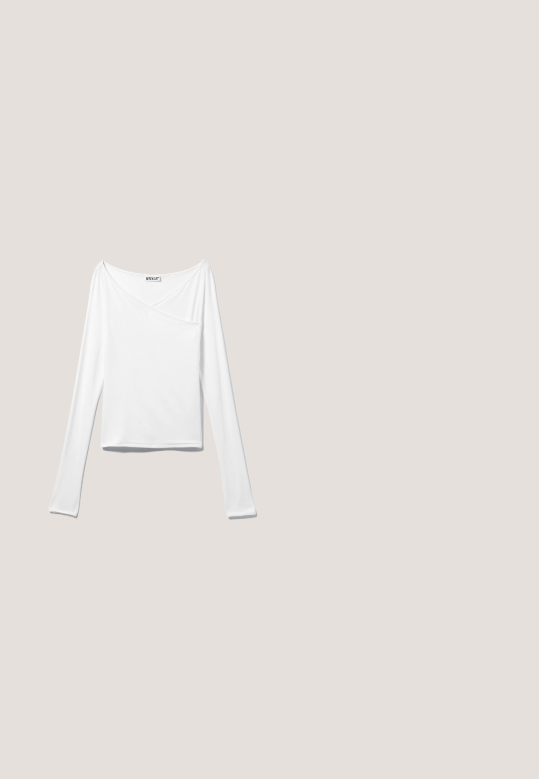 Witte long-sleeve top met een crossover ontwerp en een zak. Gemaakt van een gladde, rekbare stof. Geknipt in een casual, relaxte pasvorm.; Wijduitlopende grijze denim jeans met een licht vervaagde afwerking, voorzien van vijf zakken, een knoopsluiting aan de voorkant en lussen voor een riem.; Witte leren sneakers met zwarte strepen, gumrubberen buitenzool, ronde neus, vetersluiting en een zachte grijze suède neuskap.; Zwarte rechthoekige zonnebril met dikke monturen en bruin getinte glazen, getoond van voren op een witte achtergrond.; Zwarte glanzende leren handtas met twee handvatten, voorvak met rits en afneembare schouderriem op witte achtergrond.; Zwarte leren riem opgerold met een glanzende zilveren rechthoekige gesp en twee riemlussen op een witte achtergrond.