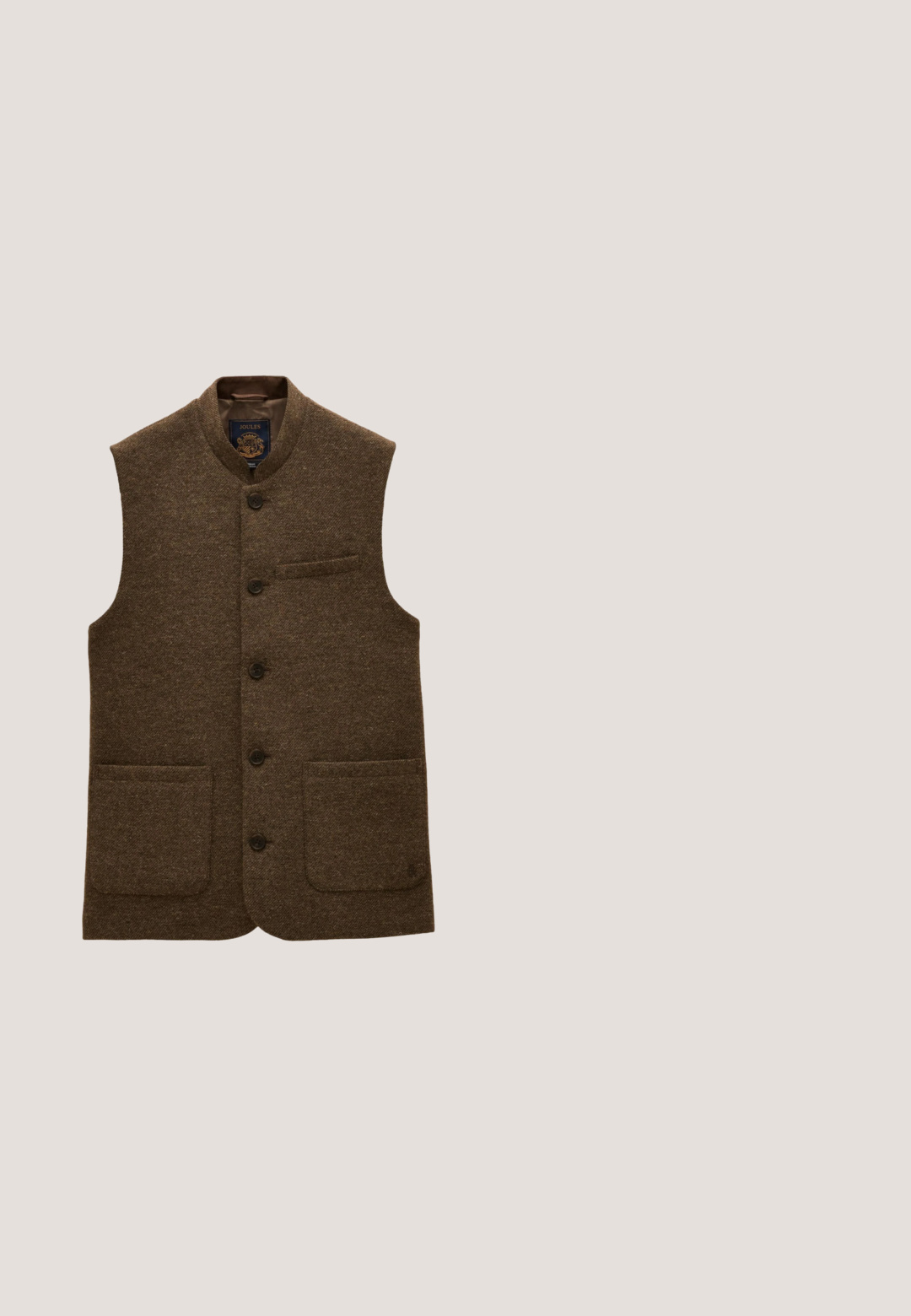 Brun uldvest med knapper foran, to nederste lommer foran, en brystlomme og en lille krave.; Brun cardigan med knapper med to forlommer og et Yale-emblem på venstre bryst. Mærket GANT i kraven indvendigt.; Beige skjorte med lange ærmer, knapper foran, en brystlomme foran og klassisk krave, vist fladt på en hvid baggrund.; Brune fløjl bukser med lige ben design, der har en frontlukning med knap og standard bæltestropper. Glat tekstur og klassisk snit.; Mørkebrun læder wingtip brogue sko med dekorative perforeringer, snørelukning og træsål med lagdelt hæl.; Brun læder messenger taske med fladt top, dobbelte spænder og en aftagelig rem, der har en glat tekstur og robuste hardware detaljer.
