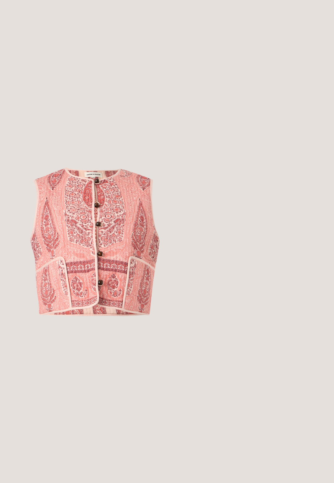 Ärmellose, rosa gesteppte Weste mit komplexen Blumen- und Paisleymustern, vorderen Holzknöpfen und zwei Vordertaschen.; Bluse mit rosa Blumenmuster, rundem Ausschnitt, kurzen Puffärmeln und Knopfverschluss. Hergestellt aus strukturiertem Stoff mit dezentem Glanz.; Beiger, plissierter Midirock mit hoher Taille, glattem Bund und gleichmäßig verteilten schmalen vertikalen Falten.; Rosa Flip-Flop mit einem glitzernden Riemen, strukturiertem Gummisohle und einfachem flachen Design. Akzente beinhalten ein glänzendes Verbindungsstück.; Rosa Lederhandtasche mit doppelten Griffen, abnehmbarem Riemen und goldfarbenem Schlossdetail vorne vor einfarbigem Hintergrund.; Goldkette mit einer Farbverlaufskette aus runden rosa Edelsteinen von hellem bis tiefem Rosa und einem kleinen Verschluss oben.