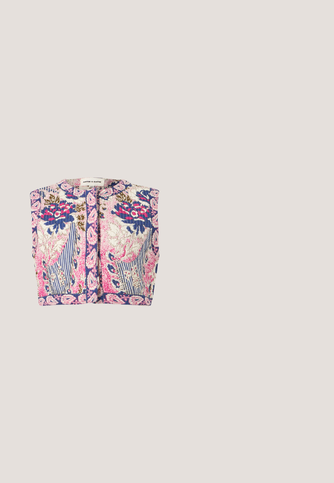 Veste courte sans manches avec texture matelassée, présentant des motifs floraux et rayés dans des tons bleus, roses, blancs et marrons, fermeture frontale à boutons.; T-shirt rose pâle à manches courtes et col rond avec manches raglan, présenté sur un fond gris uni.; Pantalons larges à fleurs en crème, avec un mélange de fleurs roses, orange et noires. Tissu lisse avec une coupe décontractée et sans poches extérieures.; Chaussure femme en cuir beige avec talon bas, bout pointu et design minimaliste, présentée de profil sur un fond uni.; Sac à main rectangulaire rose clair avec un rabat et un fermoir rond en or, équipé d'une bandoulière assortie et de ferrures dorées.; Boucles d'oreilles en acrylique transparent avec accents dorés, présentant un design incurvé et un fermoir transparent. Texture lisse, style minimaliste.
