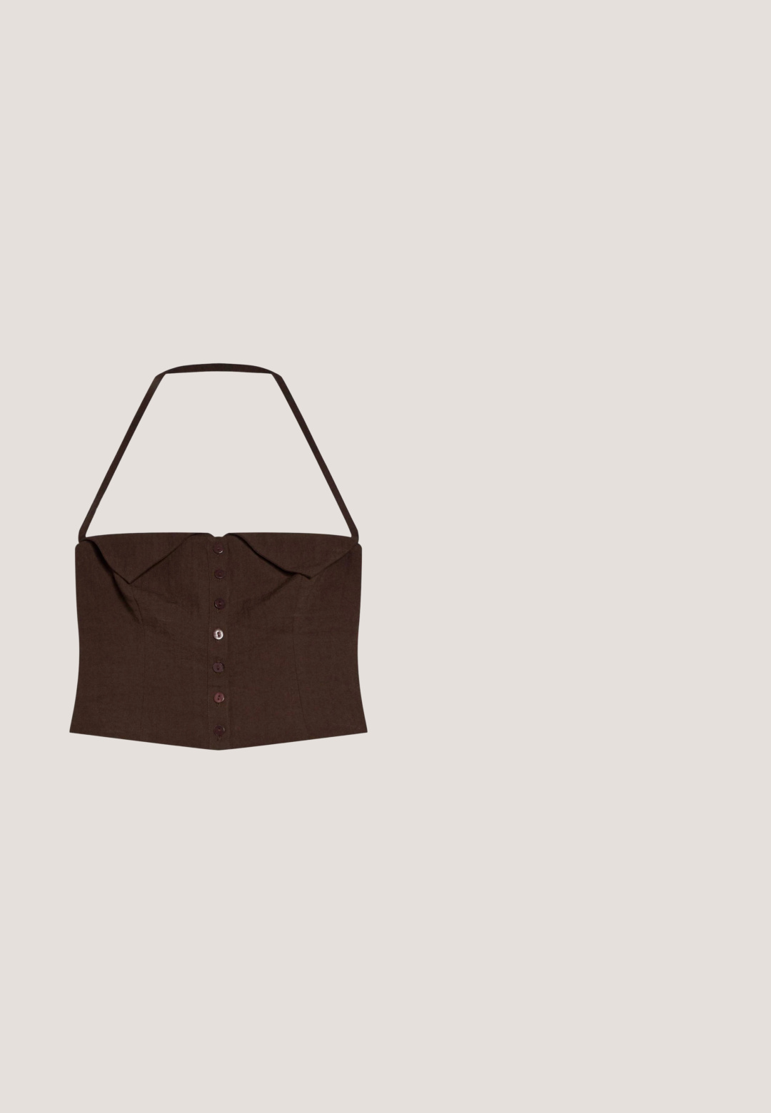 Haut court marron à col halter avec boutons à l'avant, buste structuré et large détail de col, conçu pour un ajustement près du corps.; Veste sans manches en tricot marron foncé avec un col rond et un bord en dentelle florale le long de l'ourlet, ouverte à l'avant sans fermetures visibles.; Shorts tricotés marron foncé avec ourlets en festons ornés d'un motif en dentelle florale le long du bord inférieur.; Sandale plate marron à enfiler avec deux larges brides en cuir et un petit détail de boucle dorée sur fond blanc.; Lunettes de soleil rectangulaires en écaille avec des verres teintés marron légèrement en forme d'œil de chat et une finition brillante.; Sac fourre-tout tissé marron foncé avec deux bretelles et un pompon décoratif avec de petits coquillages suspendu à une bretelle.