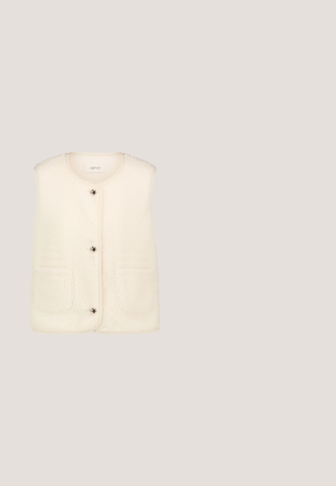 Crème wit mouwloos fleecevest met een ronde halslijn, drie metalen drukknoopjes en twee opgezette voorzakken.; Beige trui met lange mouwen en een gestructureerd patroon aan de voorkant, geribde manchetten en zoom en een ronde hals.; Beige wijde broek met hoge taille van een gestructureerde stof zonder zichtbare zakken of sluitingen tegen een witte achtergrond.; Bruine suède instap schoen met een dikke, gestructureerde zool, die intrigerende gele en bruine borduursels langs de bovenrand vertoont.; Beige tote tas met lange hengsels, subtiel herhalend patroon, klein logo in het midden en drie kwastjes die aan één hengsel hangen.; Gouden ketting met interlocking ronde hangers, één zilver en één goud, met gegraveerde details en een karabijnsluiting.