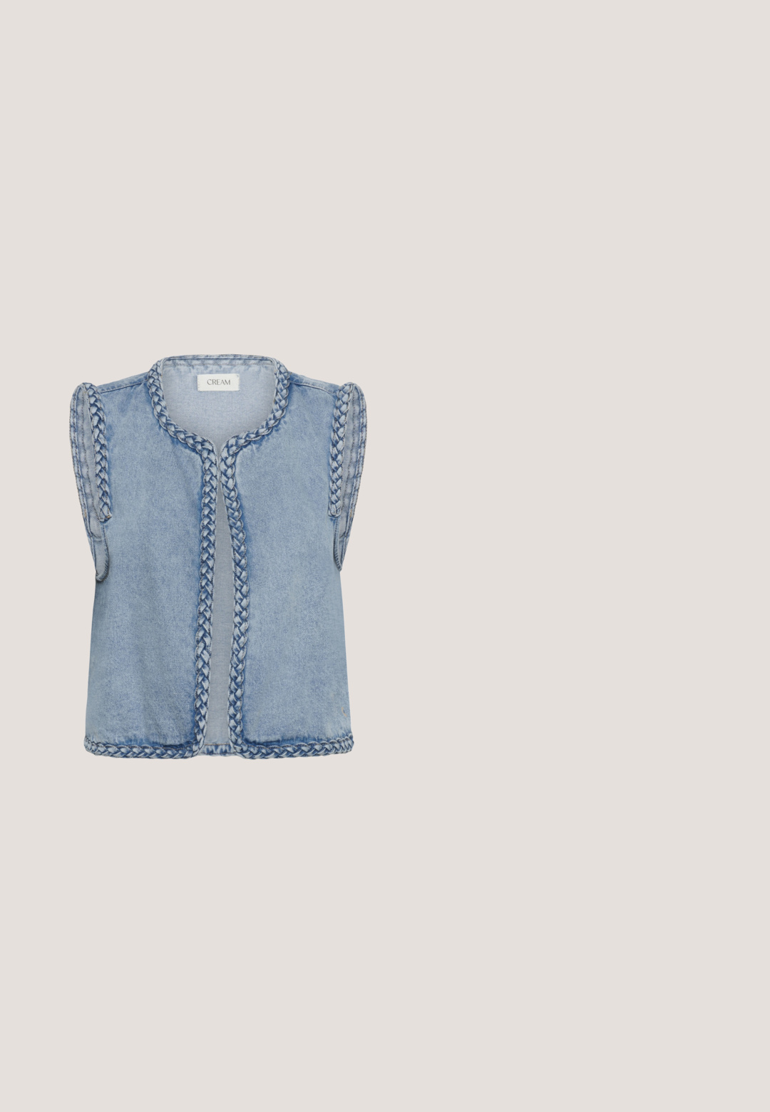 Lichtblauw denim mouwloos vest met gevlochten afwerking langs de randen, open voorkant en merketiket "CREAM" aan de binnenkant van de kraag.; Witte blouse met lange mouwen, olijfgroene bloemenborduursels, knoopsluiting aan de voorkant en een klassieke kraag.; Jeansrok met een gathered tailleband, een flared zoom en witte bloemenborduursels aan de onderkant. De stof is zacht met een gladde textuur.; Bruine suède enkellaarsjes met een puntige neus, middelgrote blokhak en minimale stiksels voor een strakke uitstraling.; Bruine suède schoudertas met gouden gesp en oogjes, voorzien van gelaagde franjes en een trekkoordsluiting.; Goudkleurige ketting met een design van afwisselende klaver-vormige schakels met uitgesneden centra, een gladde afwerking en een delicaat ontwerp.