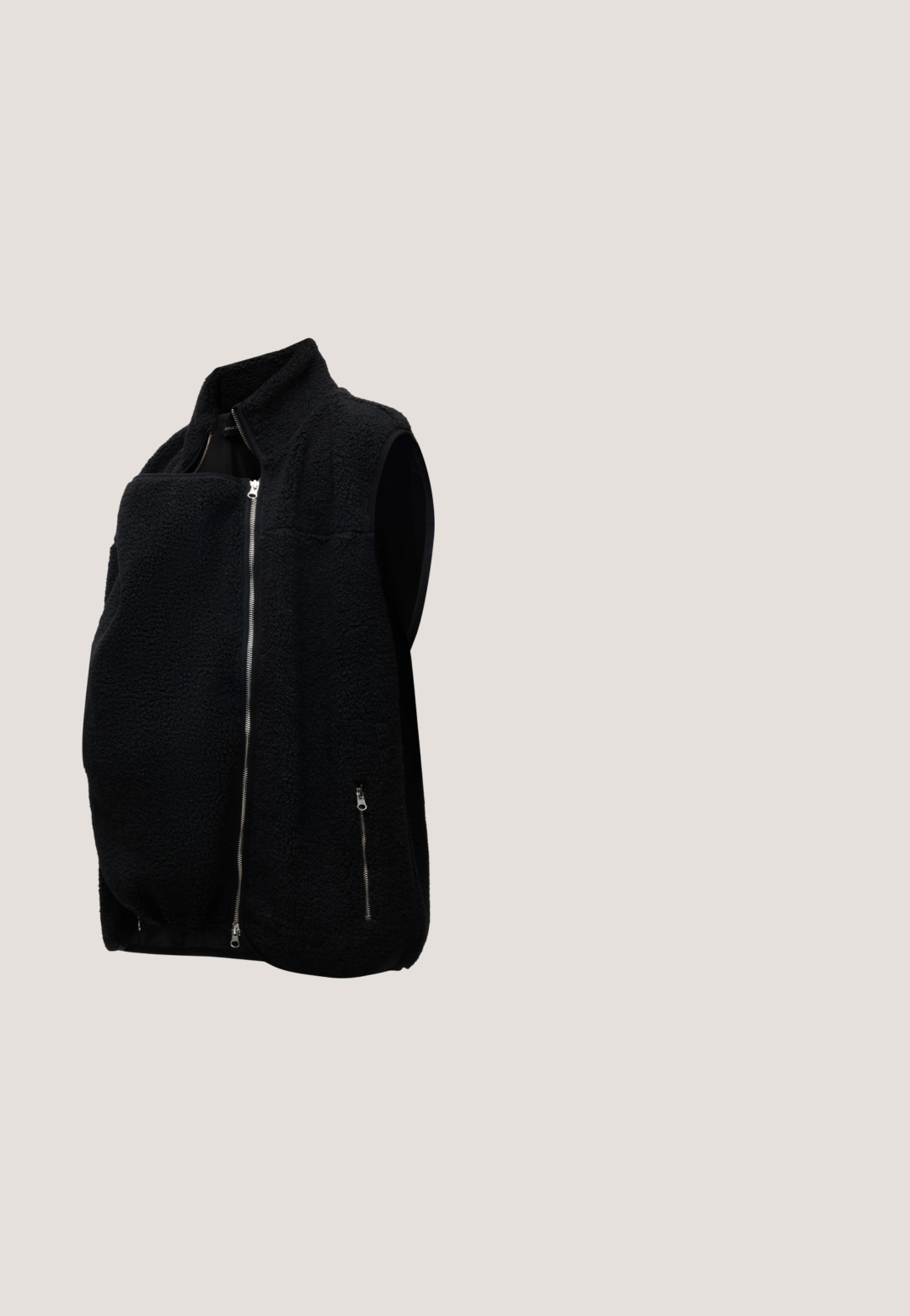 Zwarte fleece mouwloze bodywarmer met voorrits en ritssluiting aan de zijzak, ontworpen voor warmte en comfort.; Roomkleurige geribbelde zwangerschapslange mouw top met ronde hals en knoopsluiting, ontworpen om over een zwangere buik te passen.; MAMALICIOUS Slim fit Mid waist Raw hems - Slim fit jeans - grey denim; Zwarte leren enkelboot met elastische zijpanelen, ronde neus en een lage blokhak. Het oppervlak heeft een gladde textuur en minimale details.; Zwarte leren totebag met twee handvatten, een afneembare band, magnetische klepsluiting en een gladde textuur. Rits aan de bovenzijde en sierstiksels.; Twee zilveren kralenarmbanden op een witte achtergrond; één met onregelmatige kralen en de andere met uniforme kralen en een kleine druppelvormige bedel.