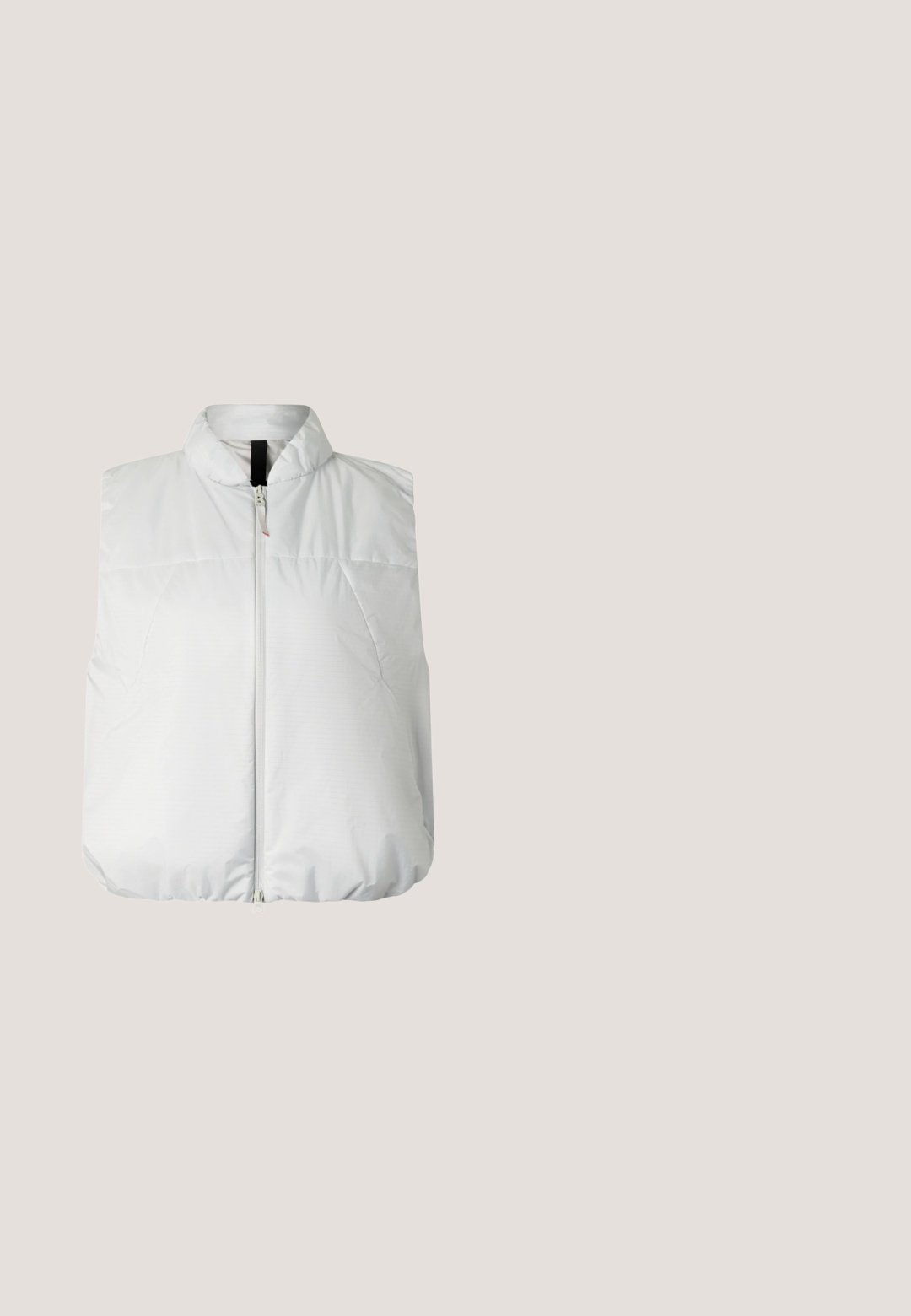 Witte mouwloze gewatteerde bodywarmer met hoge kraag en ritssluiting aan de voorkant, ontworpen voor warmte en lichtgewicht comfort.; Donkergrijze pullover met hoge kraag, halve rits en een voorvak. Heeft lange mouwen en een losse pasvorm. Glad textuur.; Lichtgrijze waterdichte broek van gladde stof, met een elastische tailleband, trekkoord en drukknopen bij de enkels.; Zwarte geïsoleerde instapschoenen met textuurzolen en een wit logo, gedragen met grijze gebreide sokken, gecombineerd met geribbelde mosterdkleurige broek.; Roxy DONNA  - Zonnebril - sje7; Lichtgrijze tote bag met twee donkergrijze handvatten en een subtiele verticale zwarte ontwerp aan de voorkant, gefotografeerd tegen een witte achtergrond.