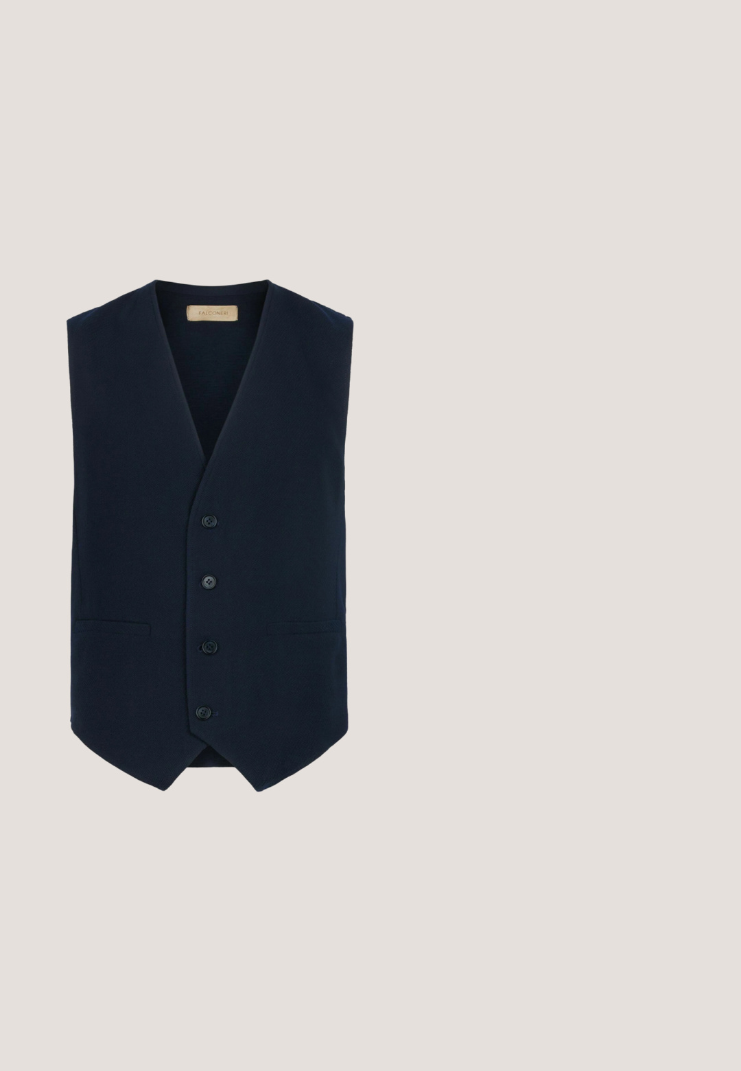 Mørkeblå vest med et struktureret stof, V-udskæring, seks knaplukninger og to forlommer. Slim fit med buet søm.; Lysblå langærmet skjorte med knapper, krave, hvide knapper og lille broderet logo på venstre bryst.; Marineblå bomulds-chinos med knaplukning, lige ben og en glat tekstur. Har sidelommer og en enkelt baglomme.; Marineblå ruskinds slip-on sko med rund tå, hvid gummisål, flettet detalje langs kanten og et subtilt logo på hælen.; Navyblåt rektangulært toilettaske med brune lærekantdetaljer, sidelomme og lynlåslukning. Lille lædermærke syet på forsiden.; Flettet stofbælte i nuancer af blå og grå, med en sølvmetalspænde og marineblå ruskindsdetaljer. Struktureret og fleksibelt design.