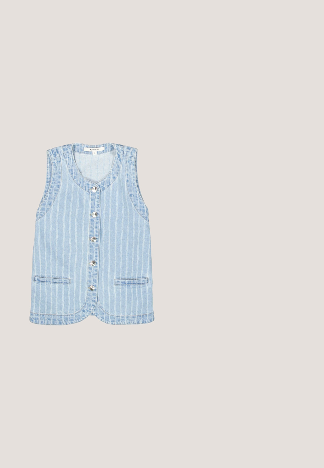 Chaleco de mezclilla azul claro con rayas blancas verticales, diseño sin mangas, cierre frontal con botones y dos bolsillos laterales.; Blusa azul claro con bordes festoneados y mangas de vuelo. Presenta bordado de ojetes y cierre de tres botones en el escote en V.; Pantalones cortos a rayas azules y blancas con bordado de encaje floral blanco, cintura elástica y dobladillo con volantes.; Zapatilla beige y azul claro con parte superior de cuero liso, detalles texturizados, cordones planos y una suela gruesa de goma marrón claro.; Bolso de mezclilla en azul claro con detalles texturizados deshilachados, dos bolsillos frontales con cremallera y una hebilla metálica decorativa. Correa corta para el hombro.; Collar de mezclilla azul con cordón ajustable y una gran decoración de tela en forma de flor adornada con pequeñas cuentas similares a perlas.