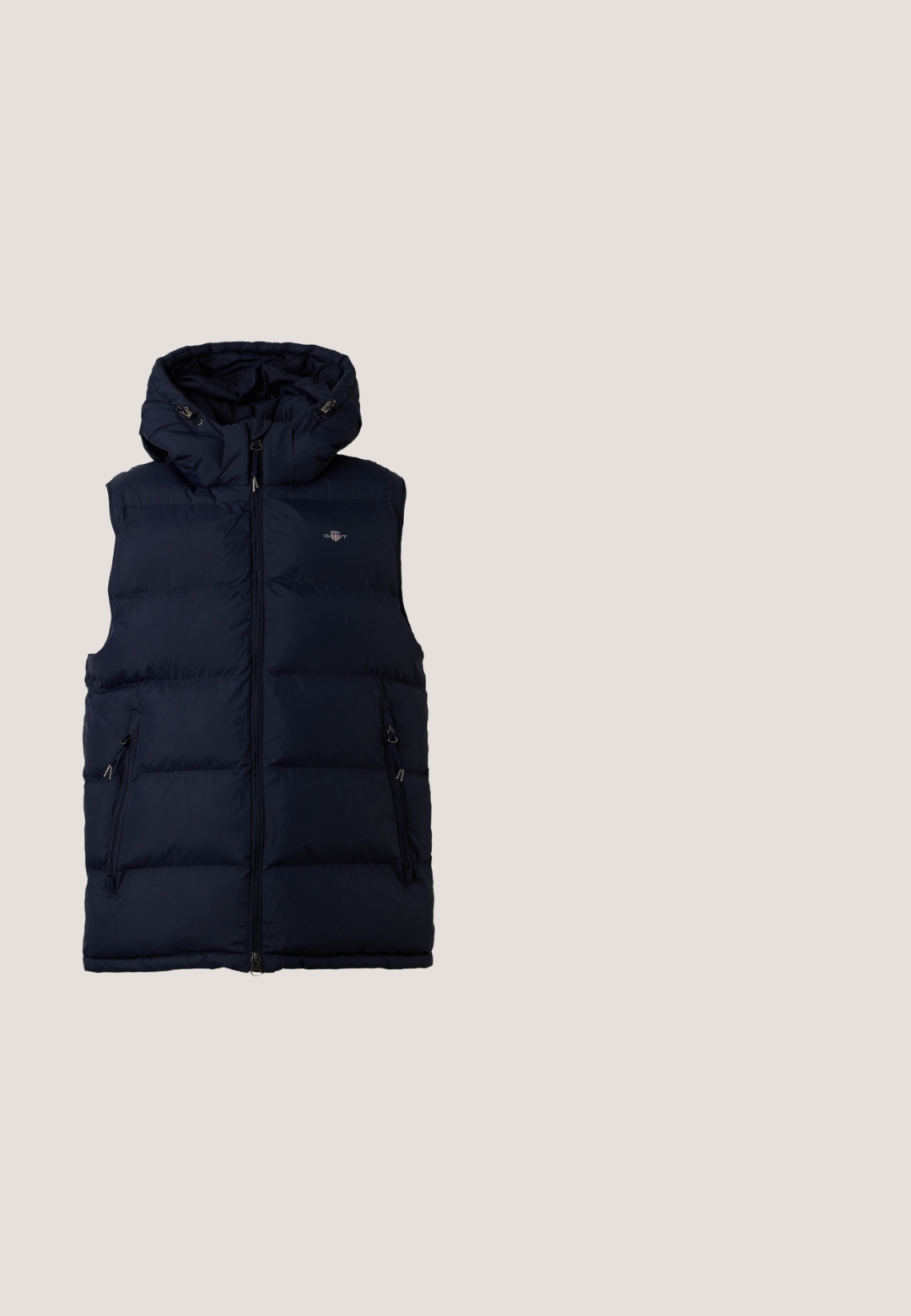 Veste sans manches matelassée bleu marine avec fermeture éclair frontale, capuche, deux poches latérales zippées et petit logo sur la poitrine.; Sweat à capuche color-block bleu marine, rouge et blanc avec poche kangourou à l'avant et logo "GAP" en grandes lettres rouges et blanches sur la poitrine.; T-shirt à manches longues bleu marine en coton avec un col rond et le logo blanc "GAP" sur la poitrine. Texture douce, coupe décontractée.; Pantalon de survêtement gris en tissu doux, doté d'une taille élastique et de jambes fuselées avec des poignets élastiques. Détail de logo discret sur une jambe.; Baskets basses de couleur crème avec des bandes latérales marron et verte, lacets blancs, semelle en caoutchouc marron clair.; Sac fourre-tout en toile bleue avec poche frontale et broderie rouge "O.N.S", doté de doubles poignées et d'une bandoulière réglable.
