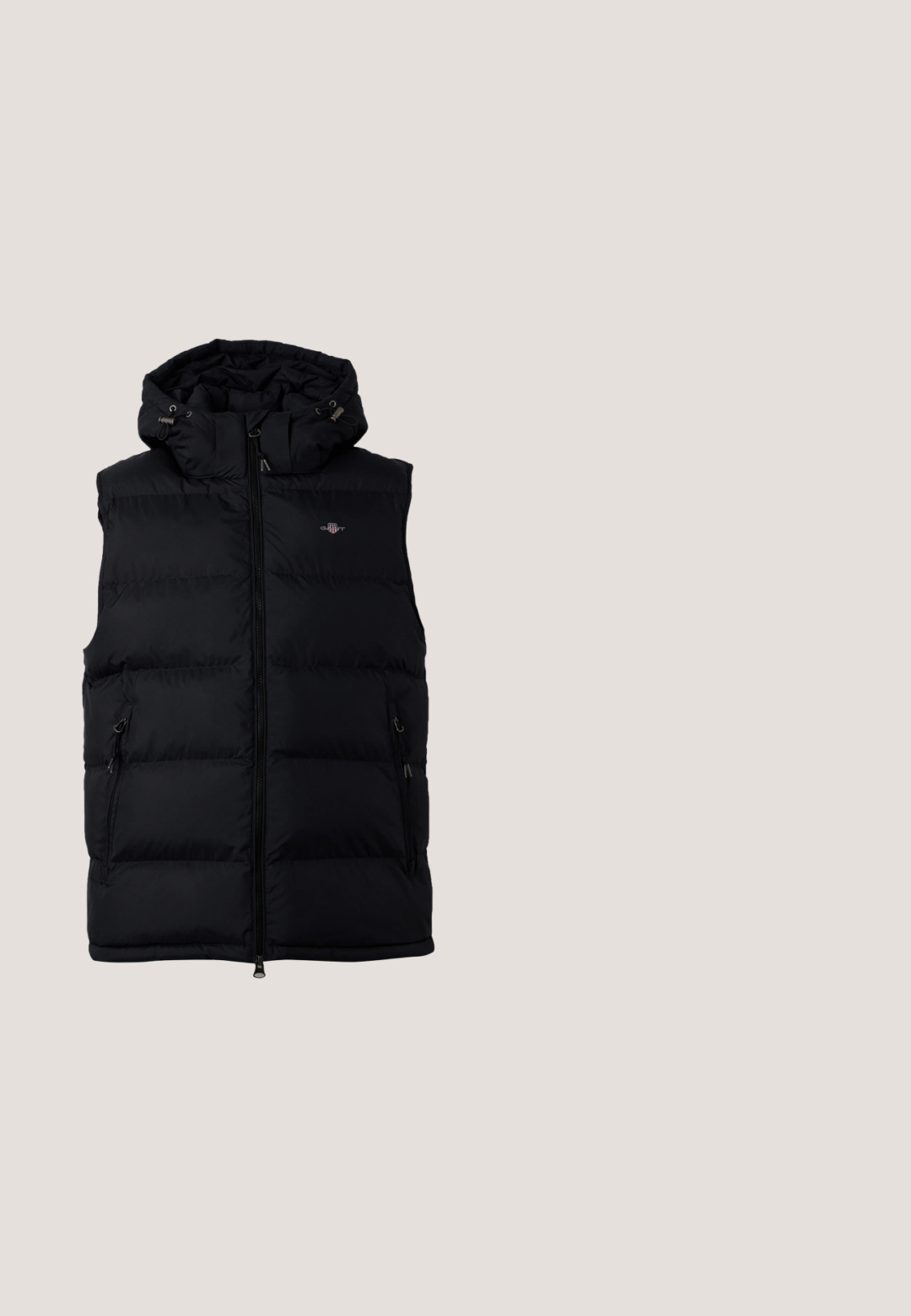 Veste noire matelassée sans manches avec fermeture éclair à l'avant, deux poches latérales zippées et capuche ajustable avec cordons.; Pull en laine blanc avec un col zippé mi-long, section supérieure texturée, motif en maille et poignets et ourlet côtelés. Détail en cuir marron sur la tirette du zip.; Chemise à manches longues en coton vert foncé avec un col rond, texture subtile et petit logo "M OP" blanc sur la poitrine gauche.; Pantalon noir en tissu doux, doté d'une ceinture à cordon de serrage, d'une coupe slim et d'une jambe fuselée. Aucun motif ou accent notable.; Chaussure de sport noire avec une tige texturée, un laçage et une semelle intermédiaire blanche contrastante ; présentée en l'air au-dessus d'une surface en bois.; Sac de sport en nylon noir avec double poignées, sangle réglable, poche zippée à l'avant et étiquette de marque. Texture lisse et forme structurée.