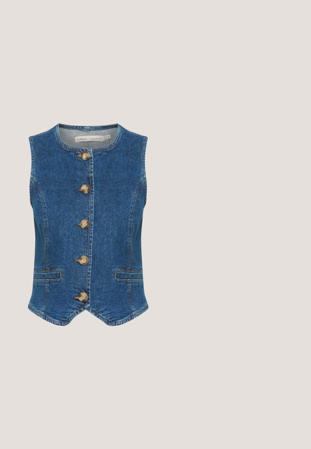 Chaleco de denim en azul oscuro con escote redondo, que presenta cinco grandes botones dorados en el frente y dos bolsillos laterales. Textura suave.; Camisa de manga corta azul claro con escote redondo, que presenta patrones bordados en forma ovalada blanca dispersos.; Pantalones de pierna ancha en azul claro, confeccionados en tela texturizada. Cuentan con una cinta elástica en la cintura y pliegues frontales para un detalle adicional.; Zapatillas de color azul claro que combinan materiales de ante y sintéticos, suela beige, cordones redondos y detalle del logo en el lateral.; Bolso tote de tela acolchada azul claro con dos asas y una correa larga, con "BIMBA Y LOLA" bordado en marrón en la parte delantera.; Pendientes dorados y azules con un diseño curvado; las secciones azules son lisas, mientras que los acentos dorados son brillantes y metálicos, montados sobre respaldos transparentes.