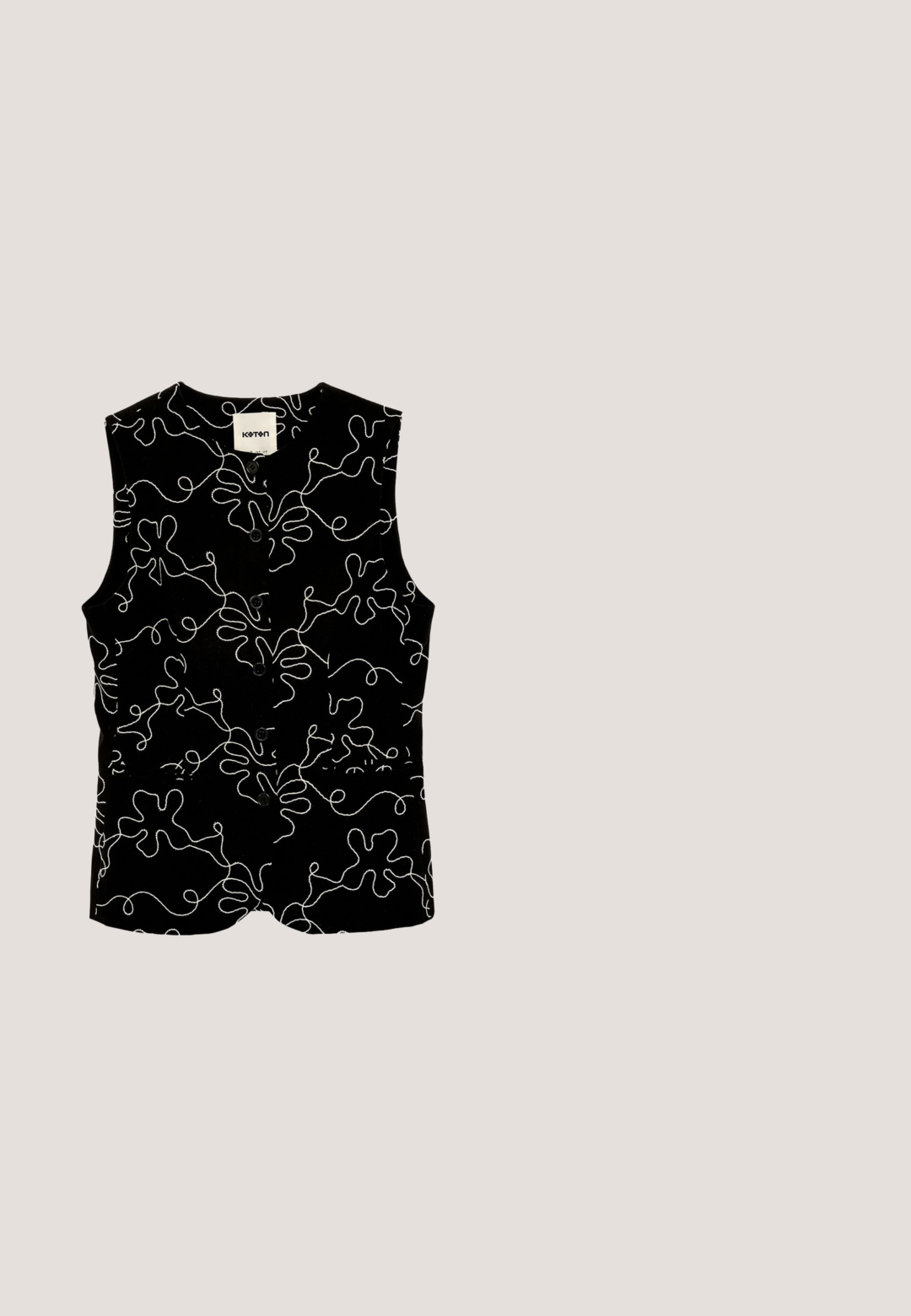 Sort ærmeløs vest med knapper, prydet med et hvidt abstrakt mønster af kruseduller og organiske former, med et lille mærke ved kraven.; Sort t-shirt med korte ærmer med hvide abstrakte swirl- og linjemønstre, rund halsudskæring og Desigual-mærke inde i kraven.; Sorte bukser med vide ben med hvide abstrakte linjemønstre og en stor stofsløjfe bundet i taljen.; Melissa MELISSA QUANTUM PLATFORM X DIESEL AD - Badesandaler - black; Sorte ovale solbriller med brune tonede linser. Har tykke plastisk rammer og slanke, buede arme. Glat overflade hele vejen igennem.; Sort tekstureret læderhåndtaske med flettede håndtag, frontlynlåslomme og aftagelig skulderrem på hvid baggrund.