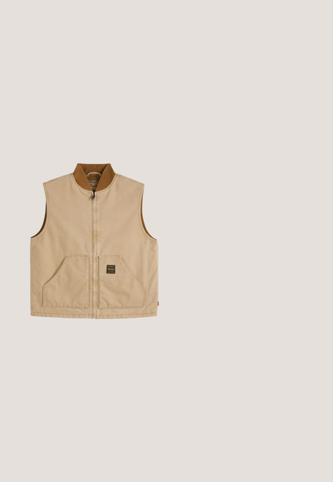 Beige ärmellose Weste mit Reißverschluss, braunem geripptem Kragen und zwei Fronttaschen, eine davon mit einem kleinen schwarzen quadratischen Etikett.; Night Addict Sweatshirt - peppercorn; Beiges Kurzarm-T-Shirt aus Baumwolle mit Rundhalsausschnitt und kleinem Brustdruck mit der Aufschrift "Originals Since 1990" in Grün und Beige.; Hellblaue Jeans mit geradem Bein, Fronttaschen, Gürtelschlaufen, Reißverschluss und einem gebrandeten Knopfverschluss an der Taille.; Sneaker mit einem cremefarbenen Lederoberteil, hellgrauen Wildledereinsätzen, runden Schnürsenkeln und einer strukturierten braunen Gummisohle, mit Markenlogo an der Ferse.; Schwarze synthetische Umhängetasche mit einem blauen quadratischen Logo, zwei Reißverschlussfächern und einem schwarzen Riemen mit Markenaufschrift.
