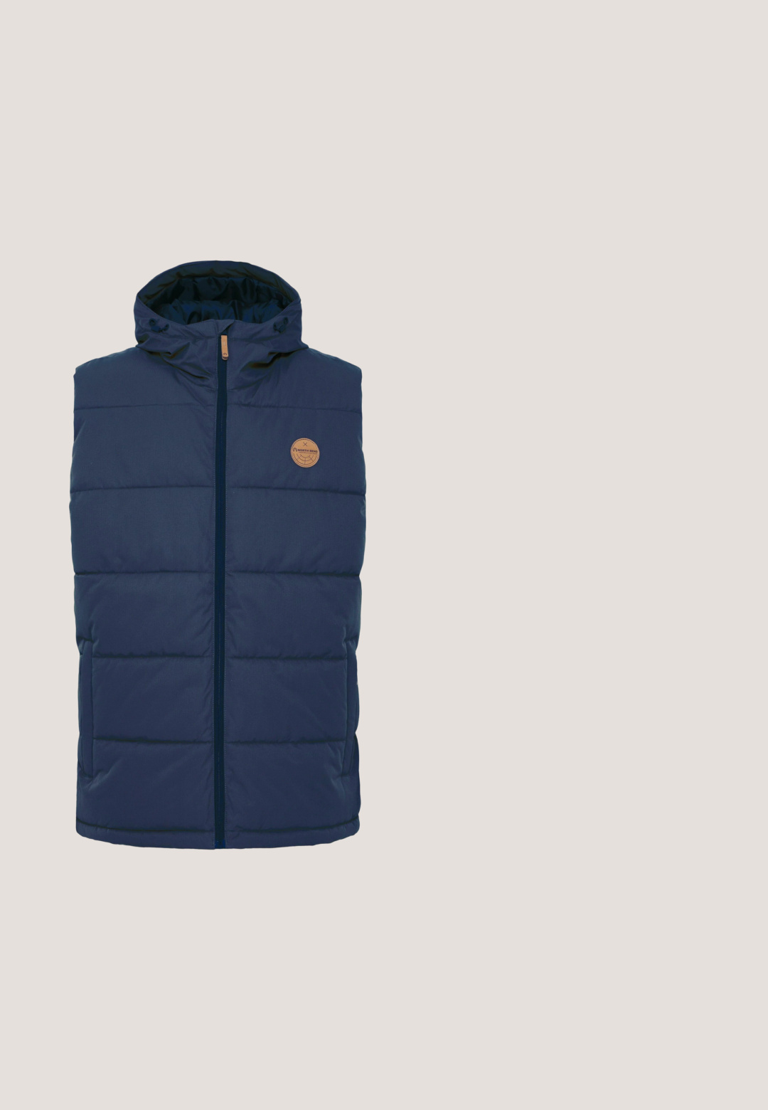 Merinovihreä pufferveste, jossa on huppu, vetoketjukiinnitys, tilkkutöistä valmistettu muotoilu ja pyöreä nahkainen logo-patch rinnassa. Sileä tekstuuripinta.; Tummansininen neulepusero, jossa on korkea kaulus, puolivetoketju ja valkoisia lumihiutaleita korostettuna punaisella rinnassa ja hihoissa.; Laivastonsininen puuvillapaita, jossa on pyöreä kaula-aukko, lyhyet hihat ja suora helma. Paidassa on pieni merkkilappu vasemmalla alhaalla.; Tummansinisiä collegehousuja, jotka on valmistettu pehmeästä kankaasta. Niissä on nauhakuja vyötäröllä, kapenevat lahkeet ja ribbikuvioidut resorit nilkoissa.; Tummansininen ja valkoinen matalakärkinen lenkkikenkä, jossa valkoiset nauhat, kumipohja ja "JACK & JONES" -logo sivussa ja koronauhassa.; Musta suorakulmainen toilettilaukku vetoketjulla ja sivukahvalla, etuosassa pieni kohokuvioitu logo keskellä.