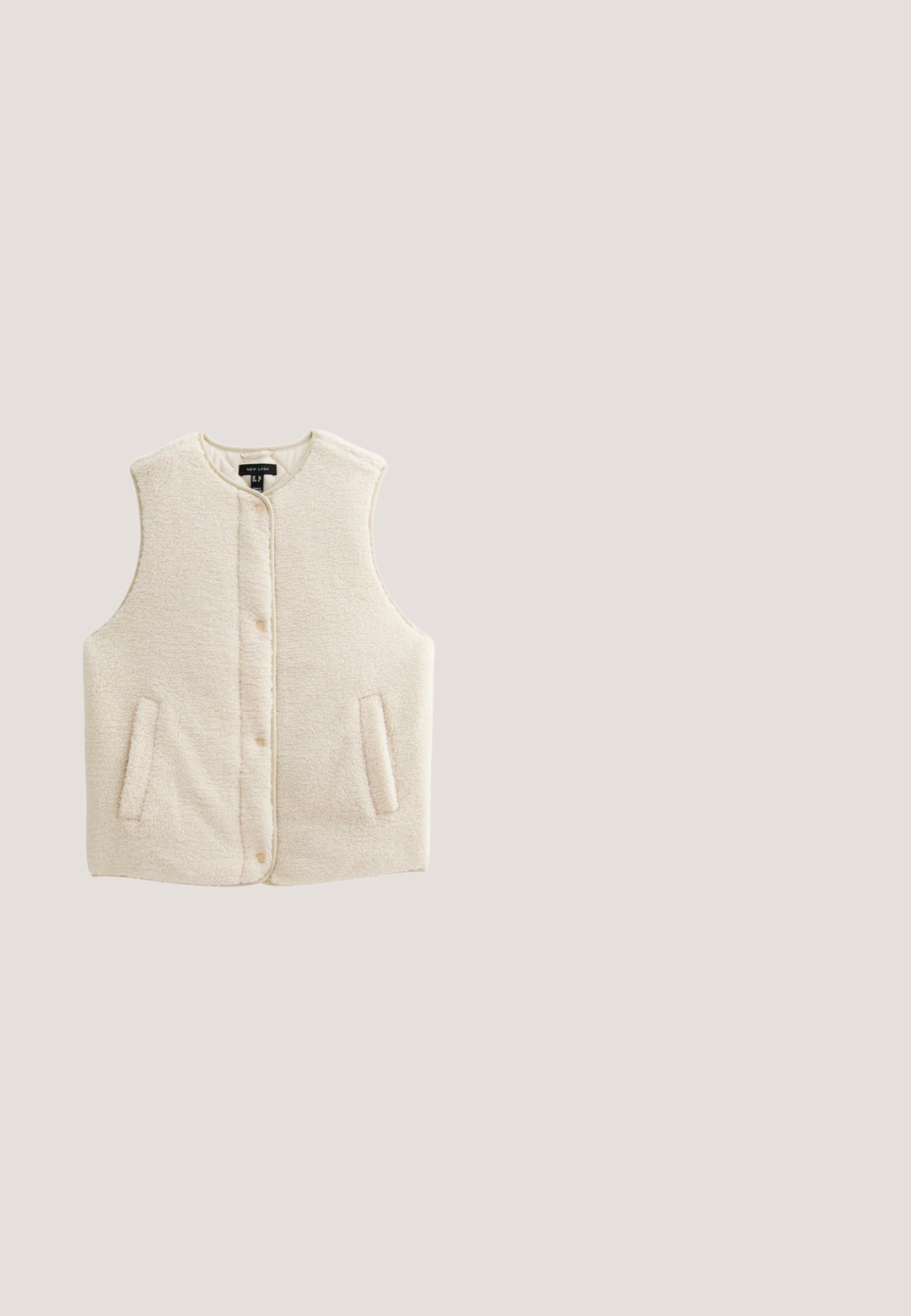 Crème-kleurige, mouwloze vest gemaakt van zachte, gestructureerde stof. Heeft een knopenfront en twee zijzakken. Zonder kraag.; Gebreide trui in zacht beige met abstracte bruin en roest patronen. Heeft een ronde halslijn en een gestructureerde stof. Merkenlabel zichtbaar.; Lichtroze T-shirt met lange mouwen en een ontspannen ronde hals, gemaakt van zachte stof met een subtiele heatherstructuur.; Beige wijde broek gemaakt van zachte stof, met een elastische tailleband met een trekkoord en een subtiele gespikkelde textuur.; Beige suède instapschoen met een zachte, fluffy crème schapenvachtvoering. Voorzien van een platte, gestructureerde rubberen zool voor grip.; Witte imitatiebont handtas met afgeronde dubbele bovenhandgrepen en een zachte, gestructureerde oppervlakte. Voorzien van een ruime binnenkant en een naadloos ontwerp.