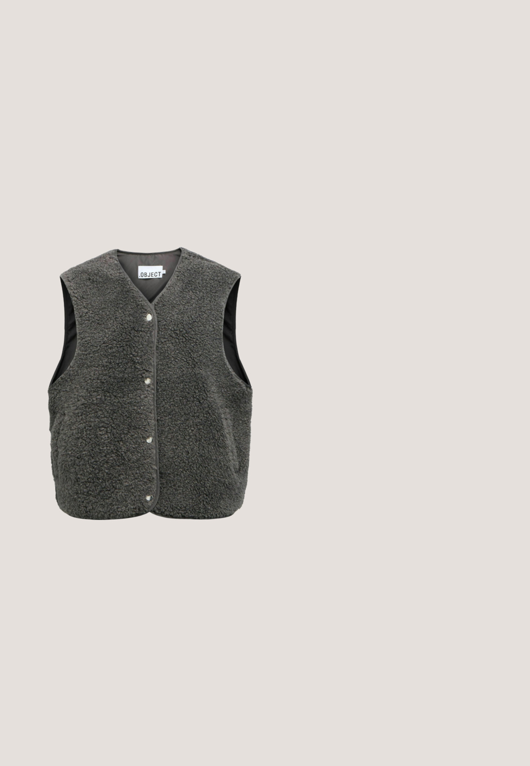 Donkergrijze mouwloze bodywarmer met gestructureerde fleece stof, drukknoopsluiting en zwarte binnenvoering.; Grijze, met lange mouwen, ronde hals trui gemaakt van zacht en soepel breimateriaal. De trui heeft ribgebreide manchetten en zoom, met een gladde textuur en een minimalistisch ontwerp.; Grijze wijde broek gemaakt van zachte stof, met een elastische tailleband en zijzakken. Glad textuur met een casual, ontspannen pasvorm.; Groene suède enkellaarsjes met een ronde neus, gestikte details en een gestructureerde zool. Voorzien van een lus aan de achterkant voor gemakkelijk aantrekken.; Donkerbruine suède handtas in halvemaanvorm met zilverkleurige hardware, een korte hengsel en een afneembare schouderriem.; Zilverkleurige metalen ketting met een glad, gedraaid lusontwerp aan de voorkant, afgebeeld tegen een effen witte achtergrond.