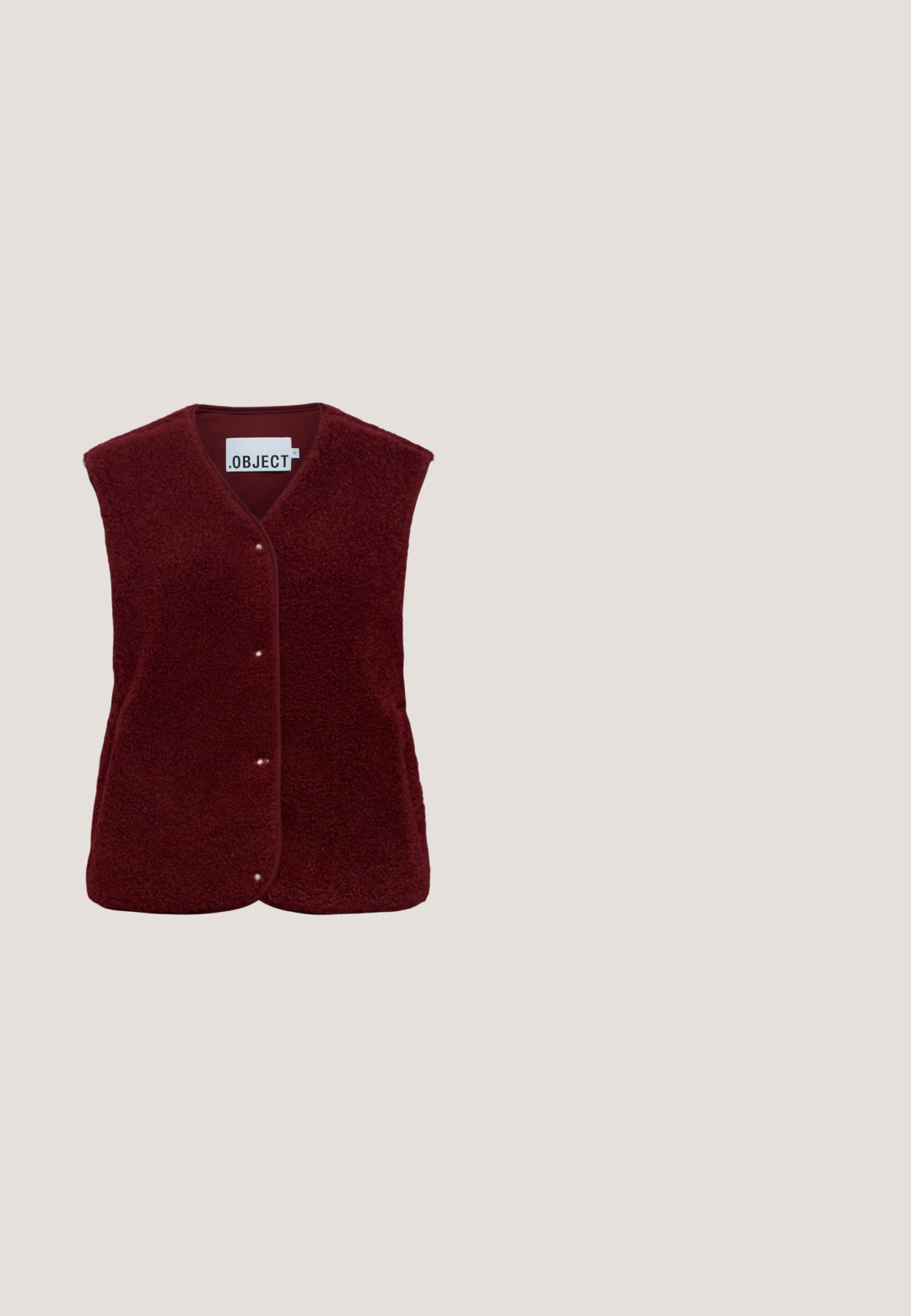 Chaleco sin mangas de forro polar burdeos con botones a presión y cuello en V, con etiqueta visible en el interior del cuello.; Suéter de punto burdeos con cuello alto, textura acanalada, mangas largas y detalles fruncidos en los hombros.; Pantalones de pana de pierna ancha en burdeos oscuro con cintura alta y detalles de botones negros en la cinturilla.; Zapatilla de plataforma baja con parte superior de ante rojo oscuro, suela gruesa marrón, cuello del talón blanco y franja lateral blanca con diseño circular.; Bolso rectangular de ante color púrpura intenso con finas correas para el hombro anudadas cerca de la base y pequeño detalle de anilla dorada en un lado.; Anillo rojo brillante con un diseño retorcido y un corte circular. Textura suave con un brillo metálico, montado sobre una banda de tono dorado.