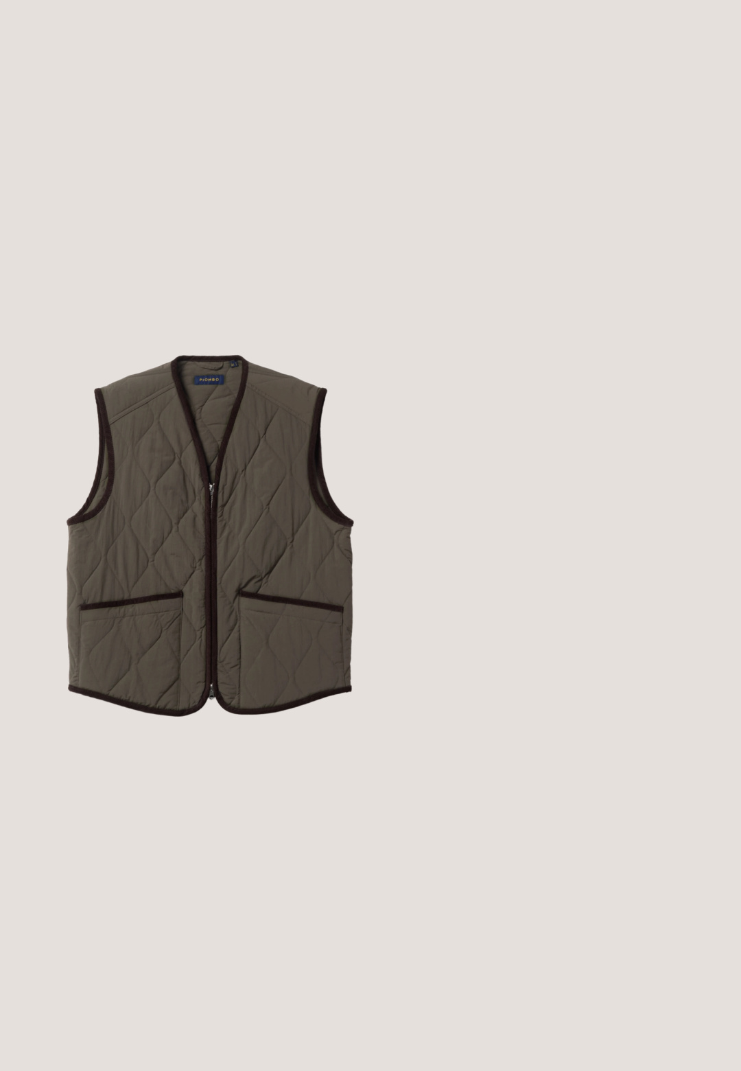Chaleco acolchado sin mangas en verde oliva con ribete marrón oscuro, cremallera frontal y dos bolsillos delanteros.; Camisa de cuadros de manga larga en tonos beige y marrón. Presenta un cierre frontal de botones, cuello y dos bolsillos en el pecho con cierres de botón.; Pantalones verde oliva con rayas verticales, que cuentan con una cintura entallada, pliegues y un diseño de pierna recta. Textura suave.; Mocasin de cuero de color marrón oscuro con patrón trenzado y una correa en la parte superior, suela plana, vista lateral.; Maletín de cuero marrón oscuro con dos asas, bolsillo delantero con cremallera y correa de hombro desmontable sobre fondo blanco.; Cinturón de ante marrón con una hebilla rectangular en tono plateado, que presenta una textura suave y múltiples agujeros de ajuste a lo largo de la correa.