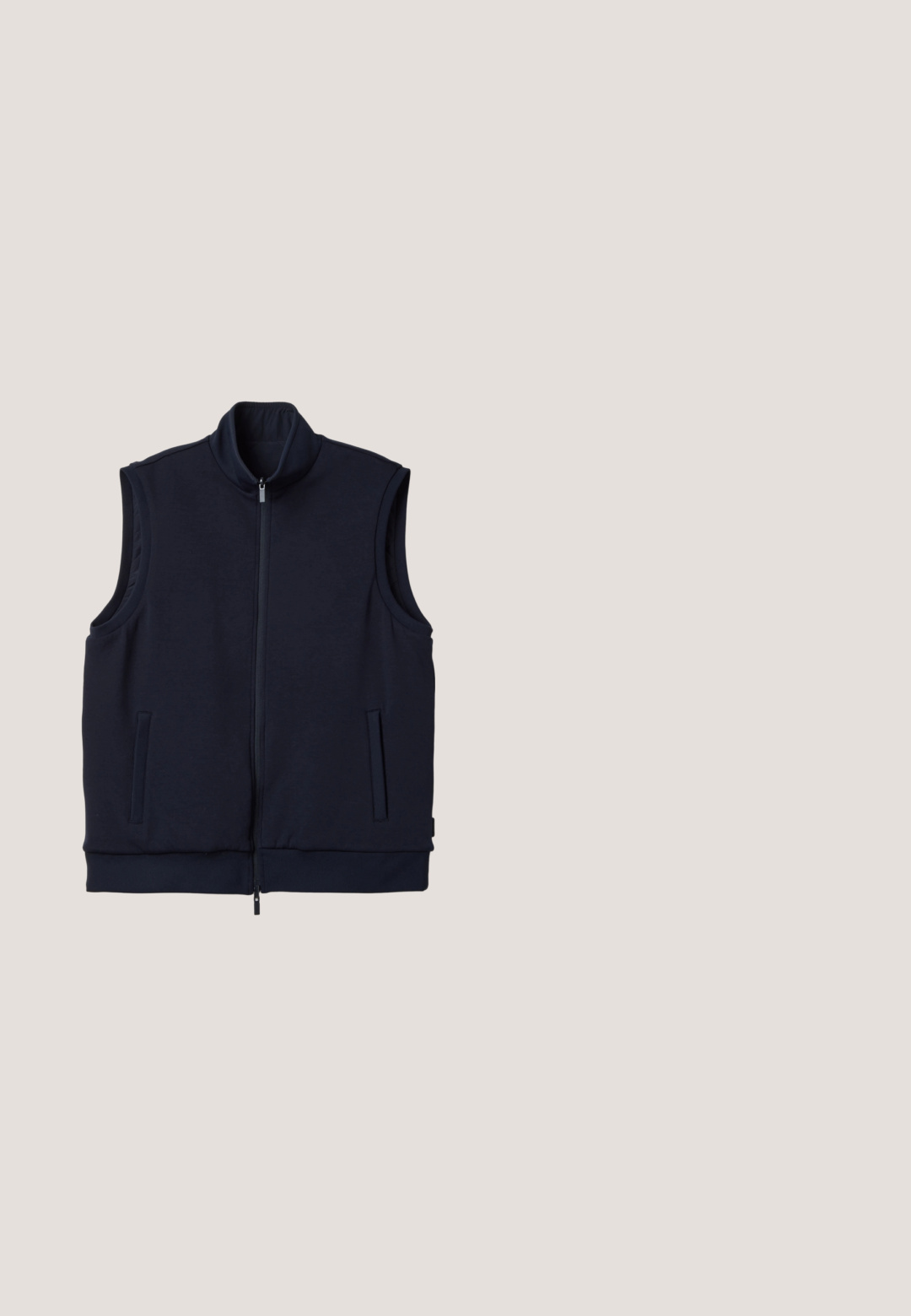 Chaleco azul marino sin mangas con cuello alto, cremallera completa en la parte delantera y dos bolsillos verticales laterales, colocado plano sobre un fondo blanco.; Camiseta azul marino de manga corta con cuello redondo, dobladillo recto y sin patrones o logotipos visibles.; Pantalones azul marino de pierna recta con cinturillas laterales elásticas, trabillas para cinturón, un solo botón delantero y cremallera.; Zapatilla de cuero blanca con puntera redondeada, suela de goma plana y costuras en tono. Presenta un cierre con cordones en la parte delantera y una lengüeta en el talón de color negro.; Gafas de sol azul marino con acabado mate, lentes cuadrados y montura gruesa. Presentan un sutil logo en la patilla.; Riñonera de cuero azul marino con bolsillo delantero con cremallera, correa negra ajustable y parche con logo negro en la esquina frontal derecha.