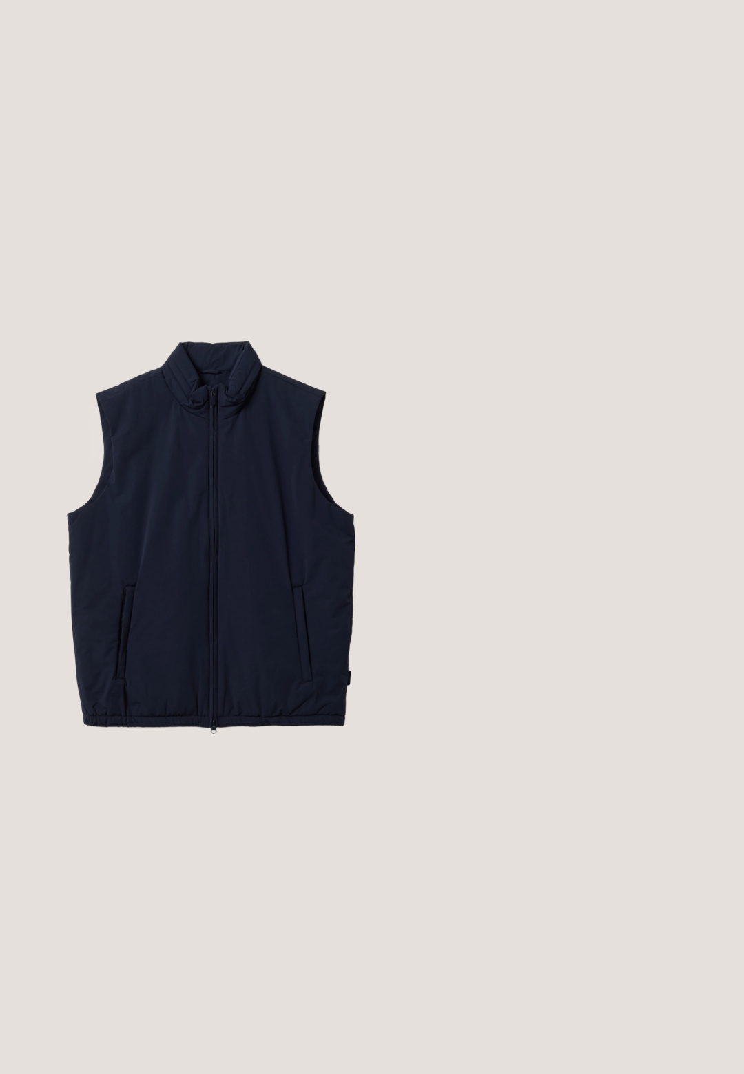 Chaleco acolchado azul marino sin mangas con cuello perkins, cremallera frontal y dos bolsillos laterales, mostrado sobre un fondo blanco.; Sudadera azul hecha de una mezcla de algodón, con cuello redondo, puños y dobladillo acanalados, que presenta un pequeño logo bordado en la parte delantera.; Camiseta de manga larga en azul marino oscuro, hecha de suave tela de algodón texturizado. Presenta un cuello redondo y un dobladillo recto.; Chinos de algodón azul marino con un diseño de pierna recta, cierre de botón, dos bolsillos frontales y una textura suave.; Zapatillas de ante marrón con suelas de goma blanca planas, diseño de cordones, punta redondeada y una textura suave. Estilo minimalista con sutiles detalles de costura.; Bolso de viaje de cuero marrón oscuro con dos asas, correa de hombro desmontable y bolsillo frontal con cremallera plateada.