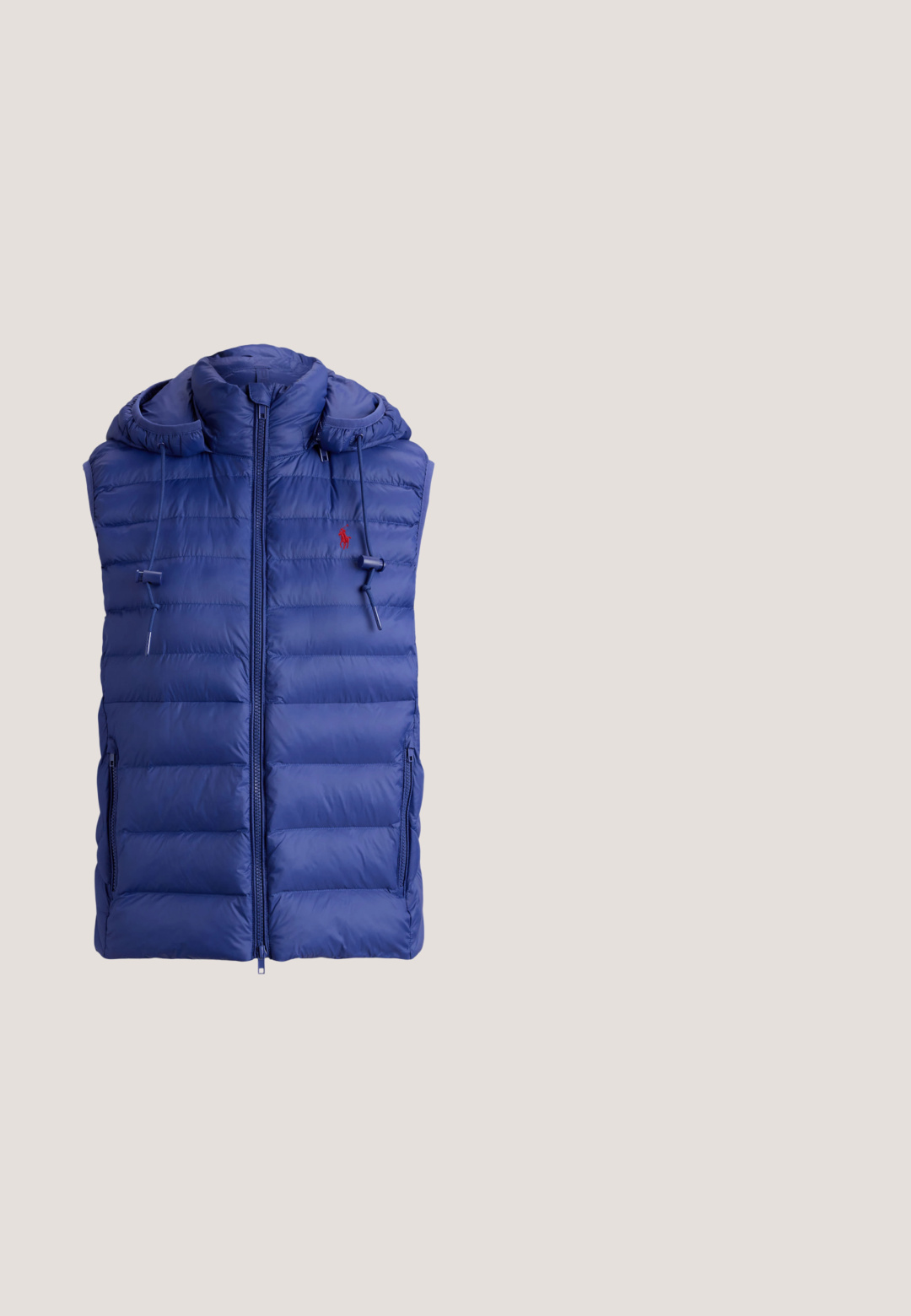 Veste matelassée sans manches bleue avec fermeture éclair devant, capuche avec cordons réglables et petit logo rouge brodé sur la poitrine.; Pull en maille bleu marine avec un motif texturé du drapeau américain en rouge, blanc et bleu. Poignets et ourlet côtelés, avec le logo « RL » près de l'ourlet.; Chemise en denim bleu à manches longues avec boutons et une poche poitrine comportant un petit logo brodé sur le côté gauche.; Jean droit en denim bleu avec cinq poches, fermeture par bouton, et une légère décoloration aux cuisses et aux genoux, posé à plat sur un fond blanc.; Baskets basses blanches avec des accents en daim marron au talon et à l’orteil, des lacets blancs et un petit logo brodé marron sur le côté.; Femme portant une chemise beige et un jean bleu tenant un sac à main en denim bleu avec une lanière marron tressée et un charm doré avec le logo RLL.