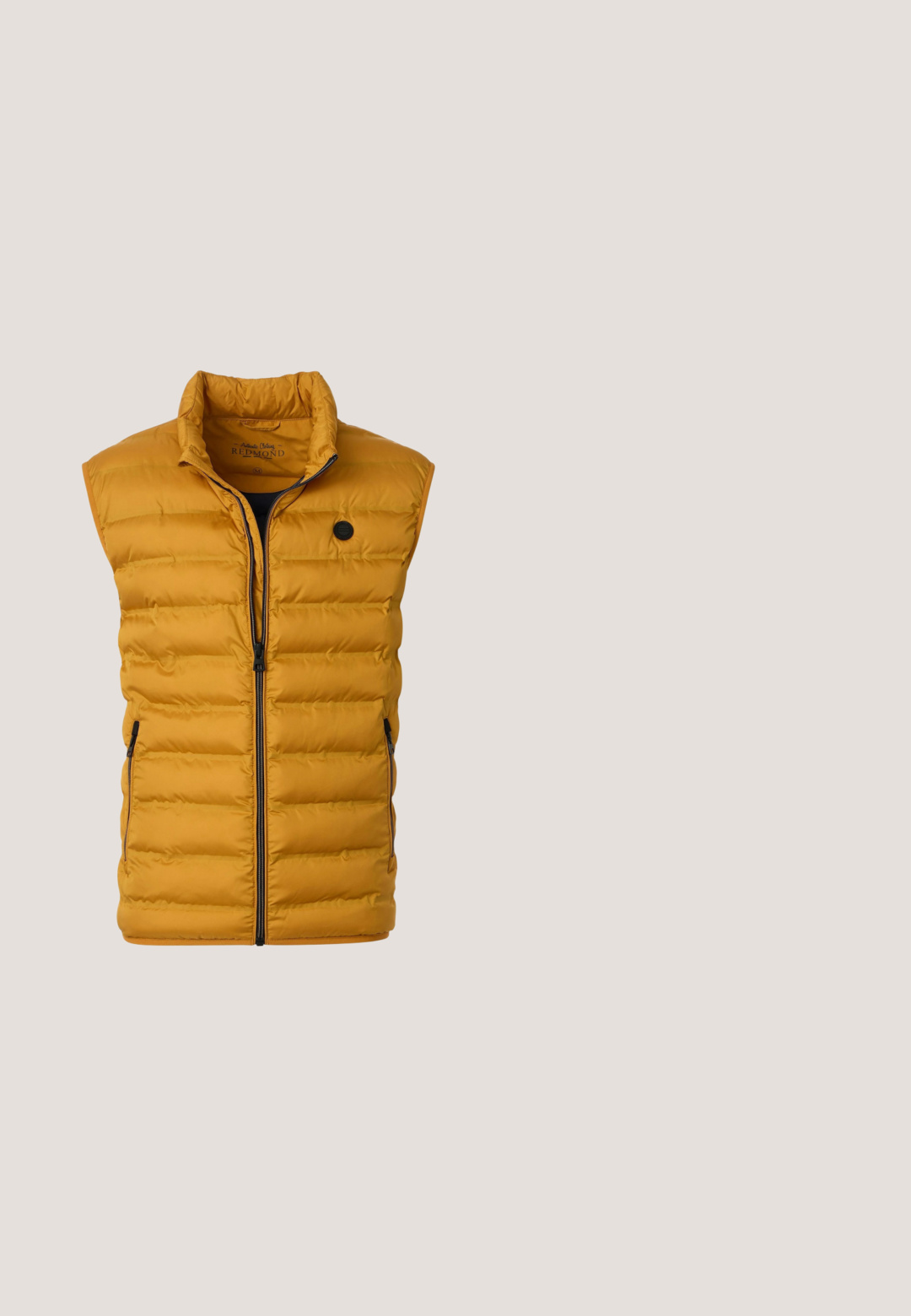 Mannenbodywarmer in mosterdgeel met gewatteerde body, voorkant met ritssluiting, opstaande kraag en met ritssluiting afsluitbare zijzakken.; V-hals trui in oranje, gemaakt van biologisch katoen. Heeft lange mouwen, geribde manchetten en een effen kleur zonder extra patronen.; Korte mouwen perzikkleurig polo met drie knopen en een klassieke kraag, van voren getoond op een witte achtergrond.; Bruine corduroy broek met een slim fit, voorzien van vijf zakken, een sluiting met een knoop aan de voorkant en een kenmerkende geribbelde structuur door het hele kledingstuk.; Tan suède sneaker met een zachte textuur, ronde neus en minimalistische veters. Voorzien van een lichte rubberen zool en een gladde afwerking aan de binnenkant.; Bruine leren schoudertas met verstelbare schouderriem, voorvak met rits en "JOOP!"-logo in het midden van het voorpaneel.