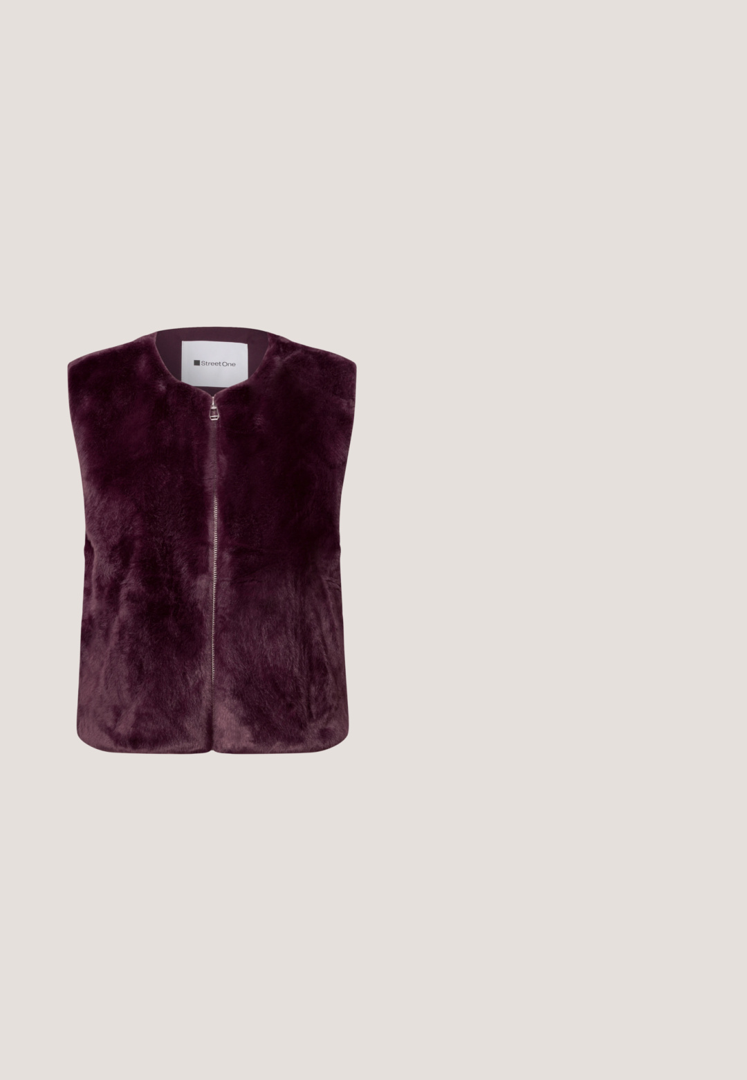 Ärmellose tief violette Kunstpelzweste mit Vorderreißverschluss und rundem Halsausschnitt von der Marke Street One.; Langärmliges Oberteil in einem satten lila Farbton, mit einem hohen Kragen, gerippter Textur und einem enganliegenden Schnitt für eine schlanke Silhouette.; Lila maßgeschneiderte Hose mit geradem Bein, ausgestattet mit einem einzelnen Knopfverschluss und subtilen Vorderfalten für einen strukturierten Look.; Burgunderfarbene Leder-Ankle-Boots mit spitzem Zeh, schlankem Design und mittelhohem Blockabsatz. Glatte Oberfläche und minimale Nahtdetails.; Burgunderfarbene Lederhandtasche mit Krokodilmuster, dreieckiger Form, goldenen Hardware-Details und abnehmbarem Riemen.; Hängende Ohrringe mit dunkelvioletten, runden, strukturierten ovalen, goldenen und unregelmäßigen dunkelbraunen steinähnlichen Perlen, vertikal gestapelt.