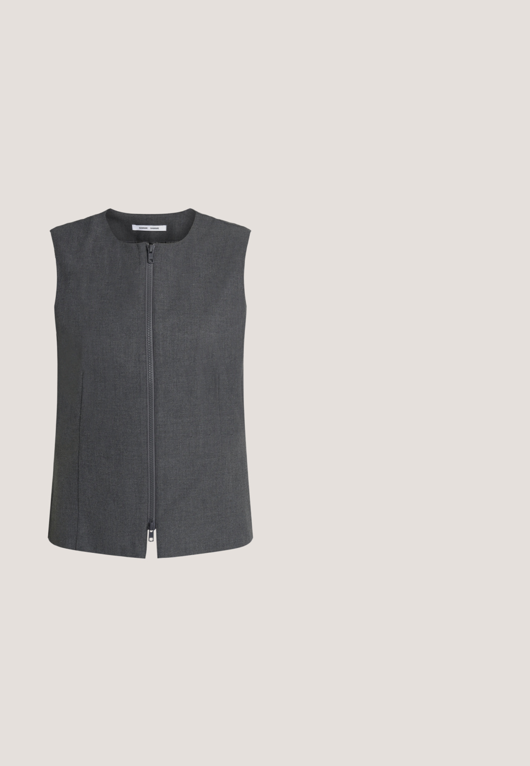 Veste sans manches gris foncé avec fermeture éclair à l'avant, encolure ronde et coutures latérales légères, présentée sur un fond clair uni.; Haut sans manches gris foncé avec col roulé haut et fermeture à bouton à l'arrière du cou sur fond blanc.; Pantalons en denim noirs à jambe large avec une taille haute, dotés de poches avant, d'une fermeture boutonnée et d'une texture légèrement délavée.; Escarpins slingback en cuir noir avec bout pointu, design ajouré et bride ajustable ornée de ferrures métalliques.; Sac d'épaule en cuir noir avec une forme trapézoïdale allongée, une sangle réglable et une plaque de marque rectangulaire argentée à l'avant.; Boucles d'oreilles en argent en forme carrée, avec une texture lisse et polie et un design simple. Aucun accent ou motif supplémentaire.