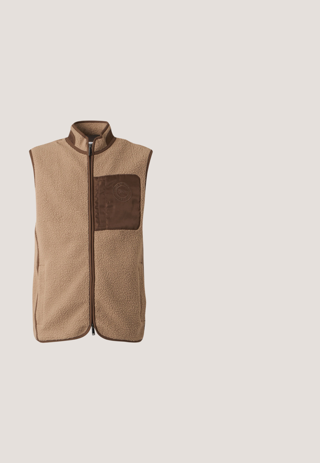 Veste sans manches en polaire beige avec bordure marron, fermeture éclair à l'avant et une poche poitrine marron avec logo circulaire embossé.; Sweat-shirt orange à manches longues et col rond avec un petit logo zèbre brodé sur le côté gauche de la poitrine sur fond uni.; T-shirt blanc à manches courtes avec un graphisme central d’un zèbre sur un fond abstrait jaune et multicolore, avec un petit texte sous le design.; Pantalon large marron avec bandes latérales à carreaux bleus et noirs et taille à lien coulissant.; Baskets jaunes en daim avec une semelle en caoutchouc crème, mettant en avant des accents marron et un design à lacets, surface texturée avec des détails de couture sur le côté.; Banane en cuir marron avec fermeture éclair. Présente quatre dessins colorés de lapins sur le devant, avec des motifs du logo MCM répartis sur toute la surface.