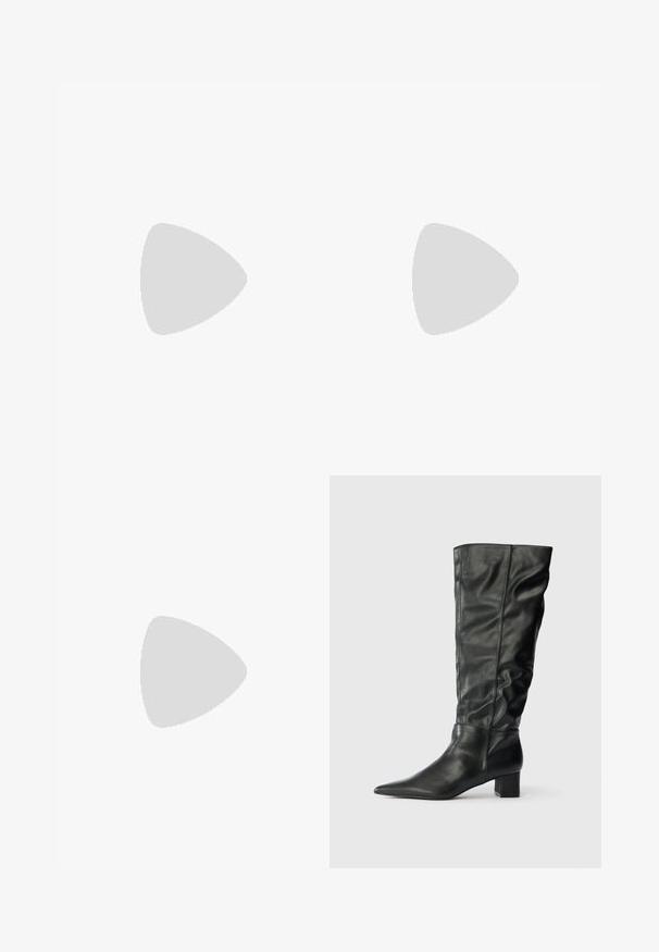 Chemise courte en jean noir avec boutons et deux poches poitrine, associée à un jean noir taille haute à jambes larges sur fond blanc.; Bottes noires en cuir jusqu'au genou avec un bout pointu, un tige décontractée et un talon carré. Texture lisse avec peu de coutures visibles.; Sac à bandoulière en cuir noir avec de grands œillets métalliques circulaires espacés régulièrement sur le devant et une seule bandoulière.; Boucles d'oreilles clip en argent avec une forme de dôme et une bande gravée "Fiorucci" autour du centre, présentant une surface polie et réfléchissante.