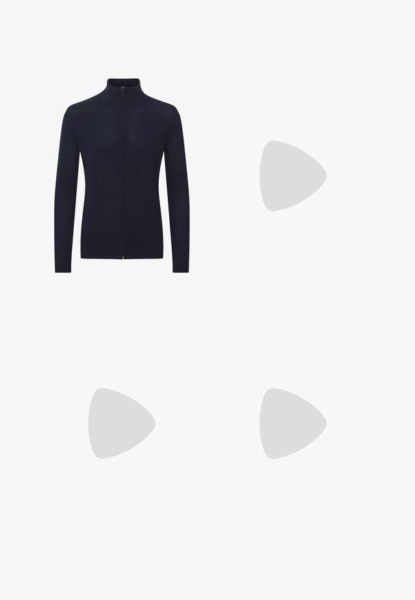 Marineblå lynlås-cardigan lavet af tekstureret strikstof, med ståkrave og en tætsiddende silhuet, samt ribkanter ved ærmerne og nederste kant.; Hvid T-shirt med korte ærmer og fed, geometrisk tekstgrafik i sort og brun 3D-stil over brystet.; Marineblå slim-fit herrebukser med bælteløkker, frontlukning med knap og sidelommer, præsenteret mod en hvid baggrund.; Hvid Adidas sneaker med grønne og røde striber, gummisål og "SPEZIAL" branding, der svæver over stensat belægning.