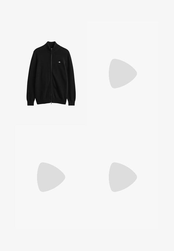 Zwarte vest met volledige ritssluiting, geribde kraag, manchetten en zoom, met een klein geborduurd logo op de linkerborst.; Witte katoenen T-shirt met ronde hals, korte mouwen en een subtiel reliëflogo op de borst. Het binnenlabel heeft een oranje accent.; Zwarte denimjeans met een rechte pasvorm, zijzakken en een knoopsluiting. De stof heeft een soepele textuur en minimale details.; Witte leren sneakers met geperforeerde accenten, platte veters en een klein groen logo aan de zijkant. Rubberen zool en gewatteerde kraag voor comfort.