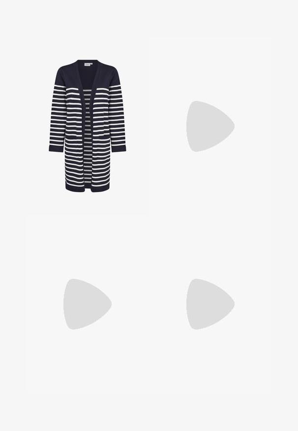 Navyblauw cardigan met verticale crèmekleurige strepen, open voorkant, lange mouwen, twee voorzakken, gladde textuur, ribgebreide manchetten.; Witte geribde tanktop met een ronde hals en brede schouderbanden. De stof lijkt rekbaar en aansluitend, geschikt voor het dragen in lagen of voor casual gebruik.; Blauwe skinny jeans van denim met een middelhoge tailleband, traditioneel vijf-pocket ontwerp en subtiele vervaging op de benen.; Zwarte hoge hak met spits toelopende neus en slingback, rustend op een glanzend, metalen zilver geknoopt oppervlak.