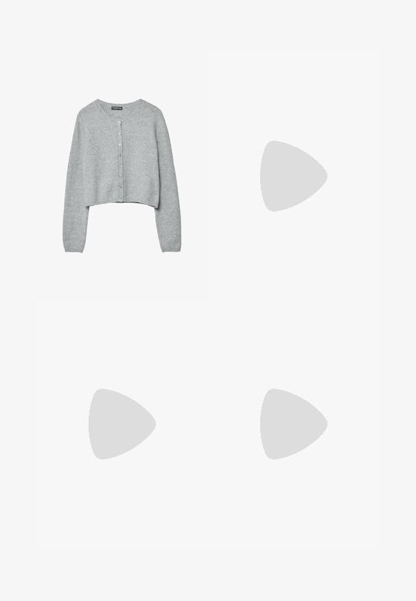 Cardigan court gris clair à manches longues avec sept boutons sur le devant, fabriqué en tissu tricoté doux.; Haut blanc à manches longues avec un design croisé et une poche. Fabriqué dans un tissu lisse et extensible. Coupé dans une coupe décontractée et ample.; Jean denim bleu à jambes larges avec poches avant et poche monnaie, fermeture à boutons, et lavage délavé sur les cuisses et les genoux.; Bottines en suede marron avec une semelle en caoutchouc plate, un bout rond et des coutures minimales, portées avec un pantalon large noir sur un sol en bois.