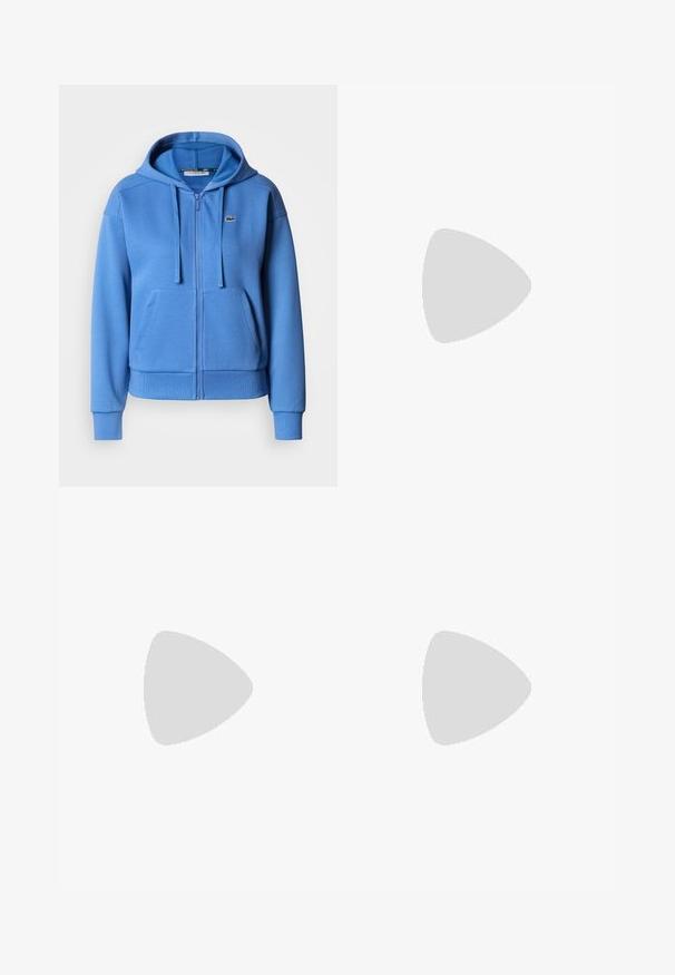 Lichtblauwe hoodie met rits, gemaakt van een katoenmix, voorzien van een kangoeroezak, verstelbare capuchon met trekkoord en geribbelde boorden. Klein logo-embleem.; Witte mouwloze tanktop met groene piping langs de halslijn en armsgaten; heeft een klein geborduurd logo op de linkerkant van de borst.; Zwarte brede jeans gemaakt van denim, met vijf zakken, koperen klinknagels en een klassieke knoopsluiting. Glad van textuur met een strakke uitstraling.; Zwarte leren enkelboot met een spitse neus, een slanke silhoeet en een chunky vierkante hak. Gladde textuur met minimale stikdetails.