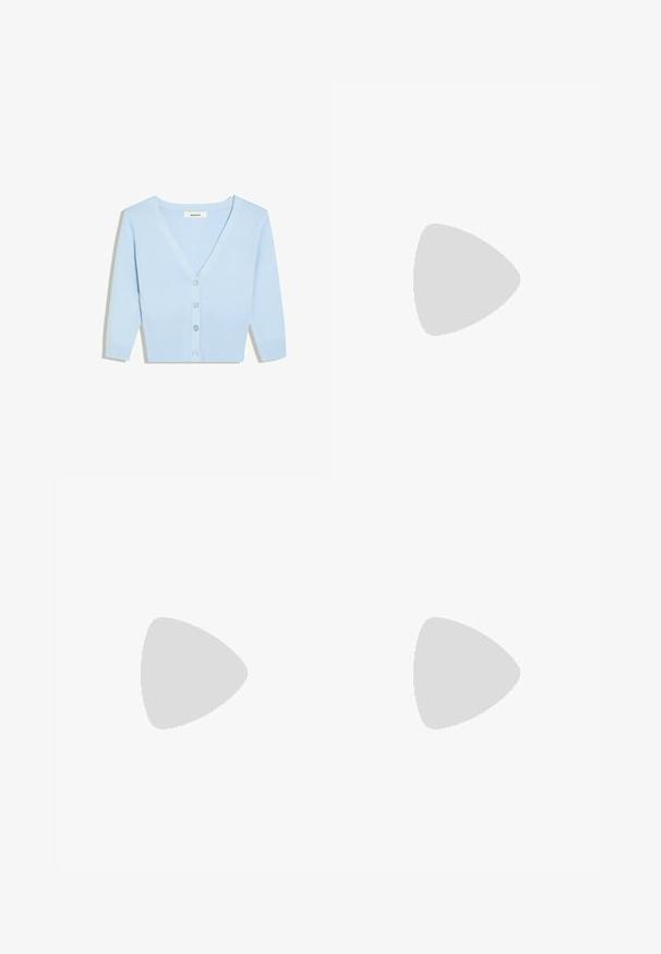 Lichtblauw cropped vest met lange mouwen, V-hals, geribde zoom en vier knopen aan de voorkant.; Witte blouse met grote geschulpte kraag, goudkleurige knopen aan de voorkant en volumineuze korte pofmouwen.; Witte rok met een geplooide taille en zwarte stippen, met een gelaagd ontwerp dat volume en textuur toevoegt.; Zwarte leren platte schoen met een dunne verstelbare band en een kleine gesp over de wreef, en een spitse neus.