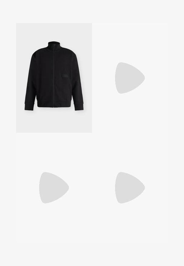 Veste noire zippée avec col montant, manches longues, poignets et ourlet côtelés, et un petit patch rectangulaire sur la poitrine.; T-shirt beige en coton à manches courtes et col rond avec une coupe décontractée et des détails de couture subtils sur un fond clair.; Jean beige et gris clair à jambes larges, avec poches avant, passants de ceinture et fermeture par bouton.; Mocassin en cuir noir avec un empeigne crème et des rayures noires, présentant un petit talon et des coutures détaillées le long des bords.